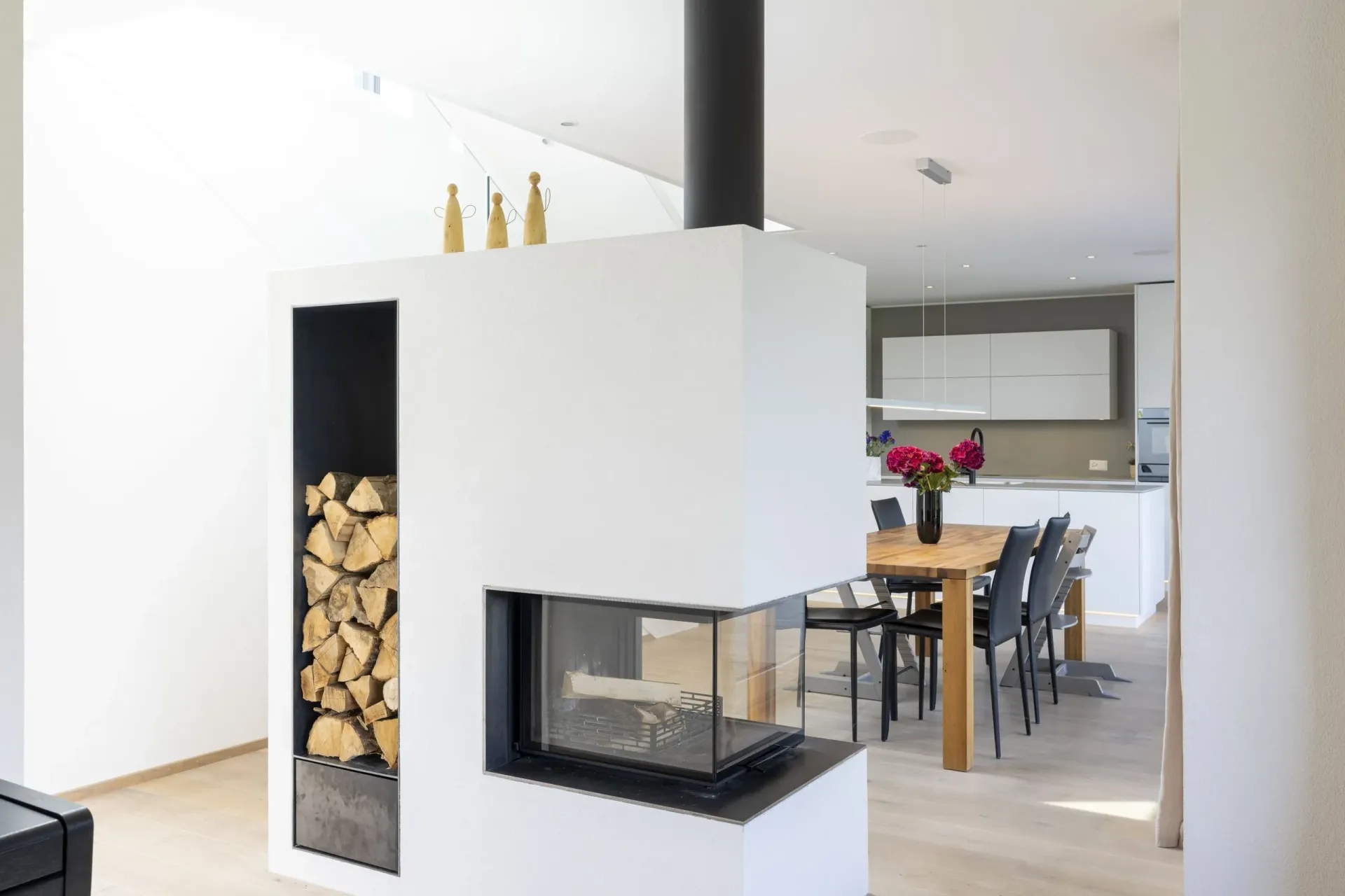 Ein Wohnzimmer mit Kamin und ein Esszimmer im Hintergrund