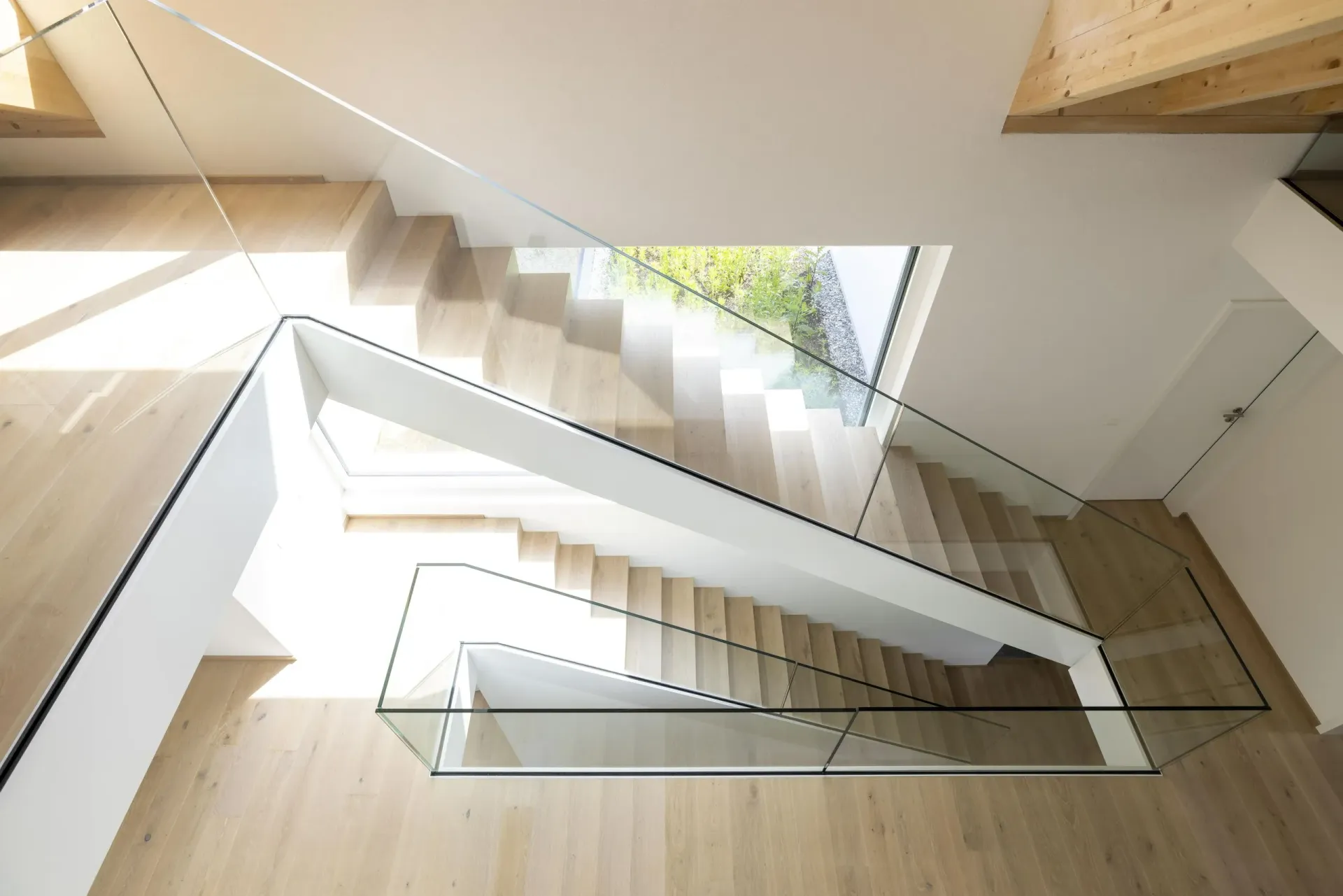 Die Treppe ist aus Holz und hat ein Glasgeländer