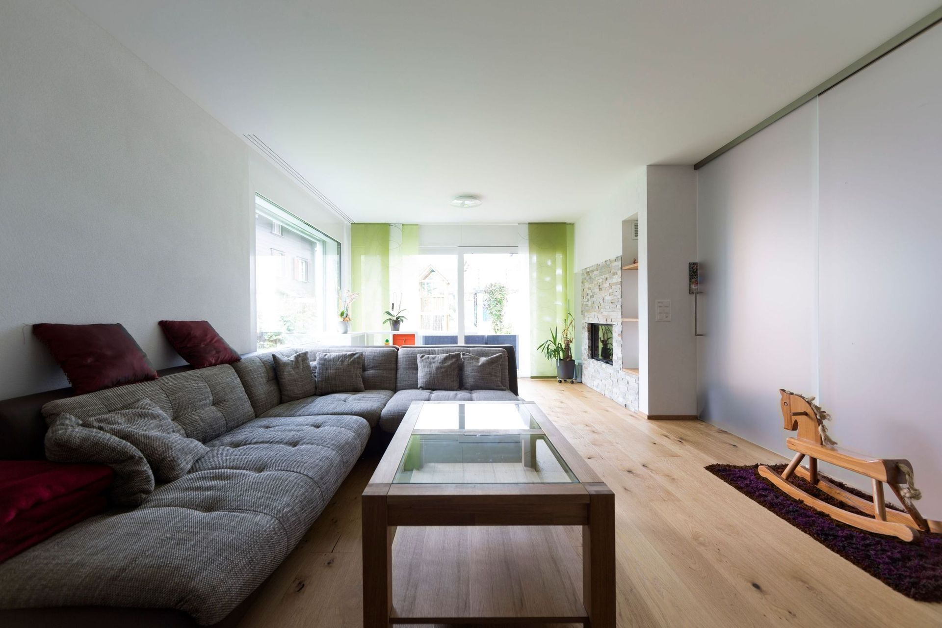 Ein Wohnzimmer mit einer großen Couchgarnitur und einem Schaukelpferd