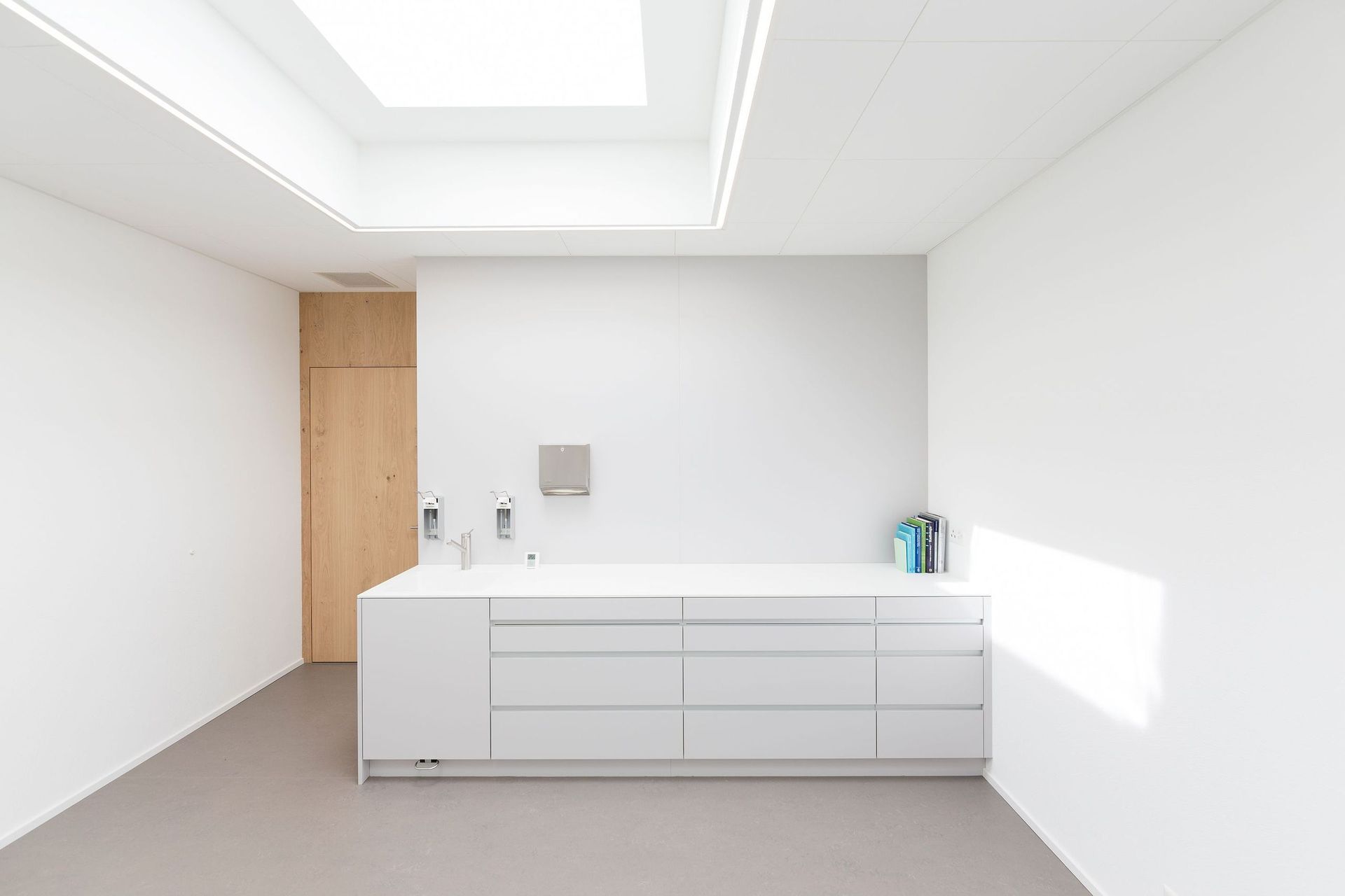 Eine Küche mit weißen Schränken, einer Spüle und einem Oberlicht.