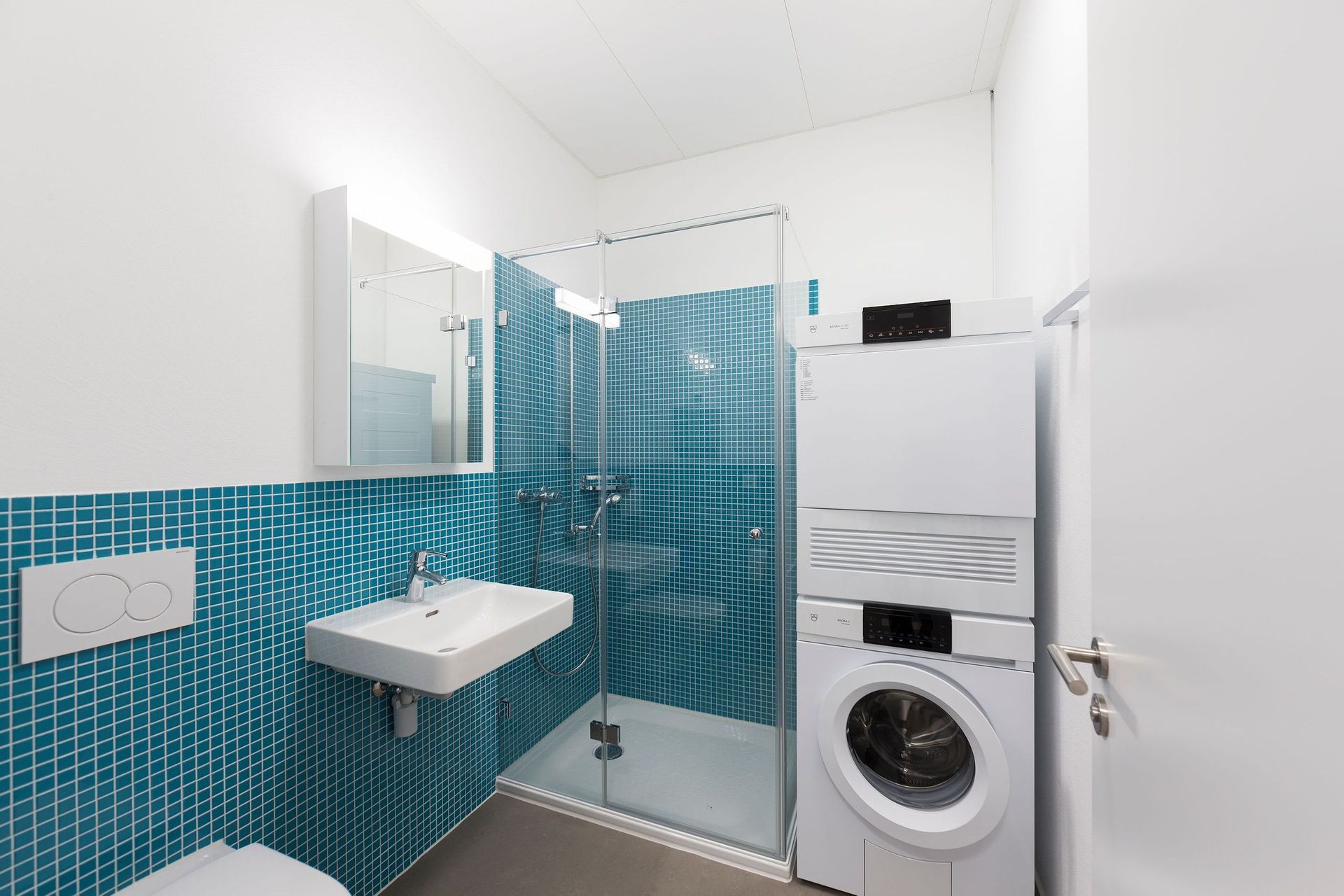 Ein Badezimmer mit einer übereinander gestapelten Waschmaschine und einem Trockner.
