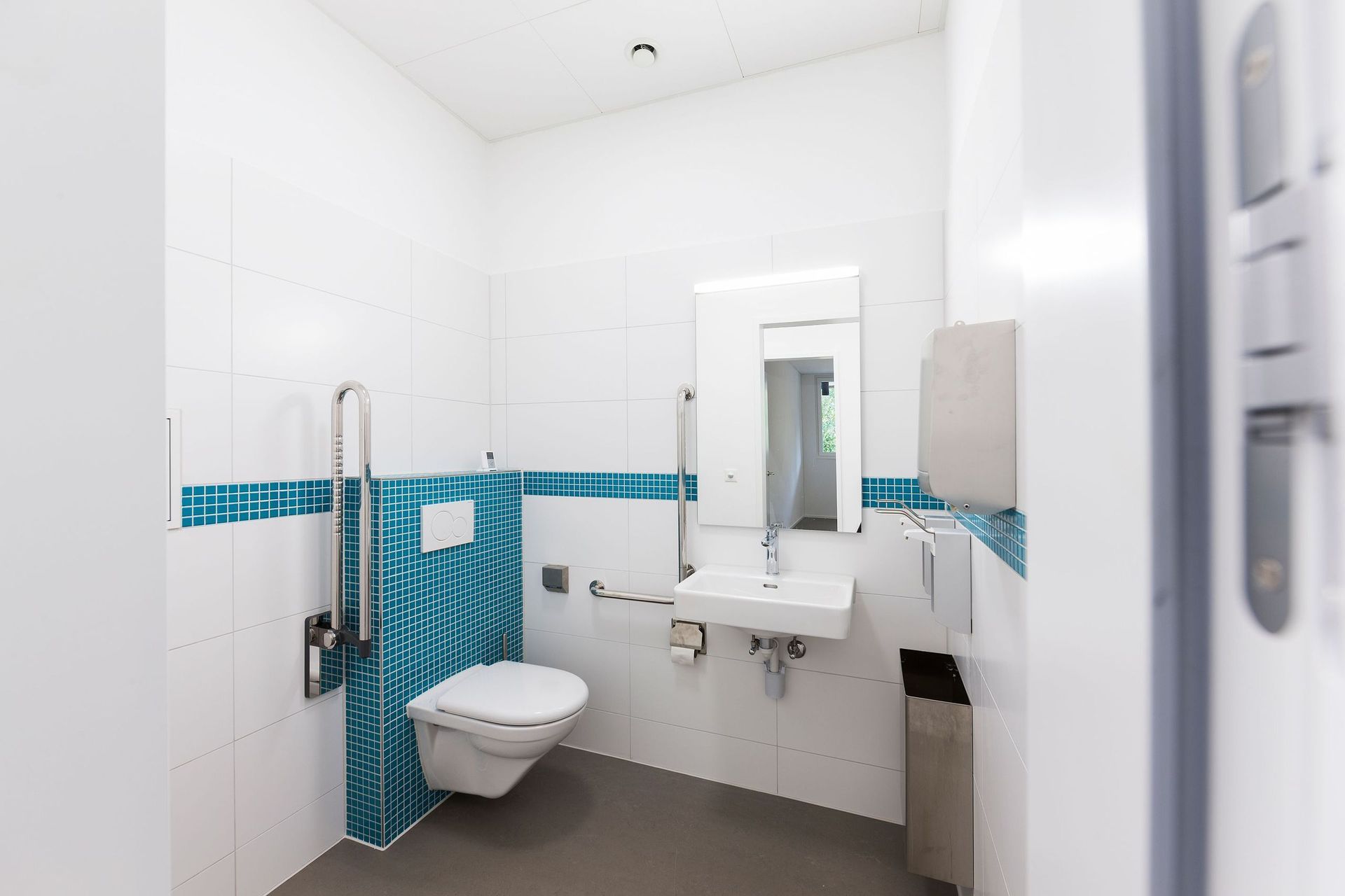 Ein Badezimmer mit Toilette, Waschbecken und Spiegel.