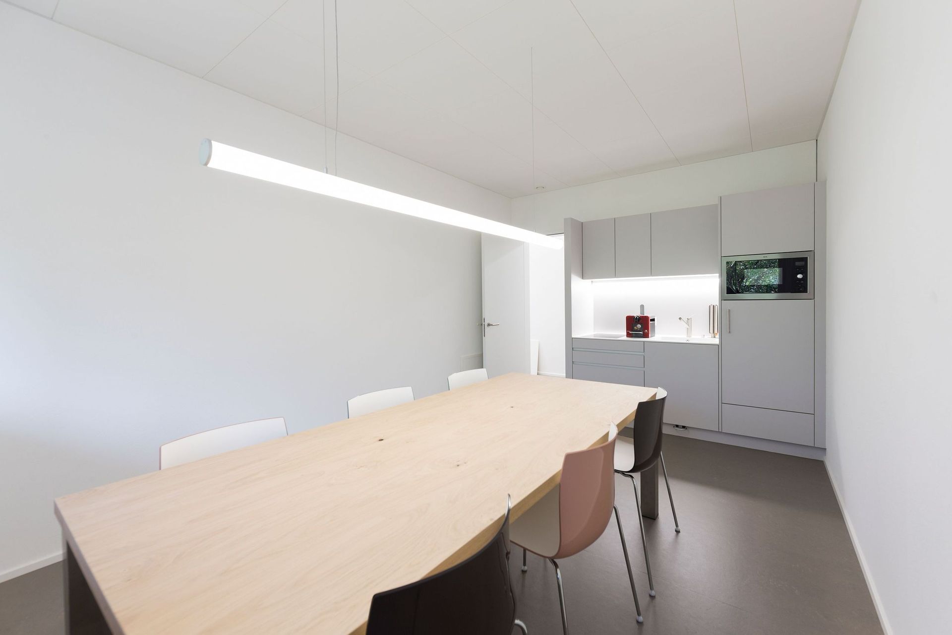 Ein Esszimmer mit einem langen Holztisch und Stühlen.