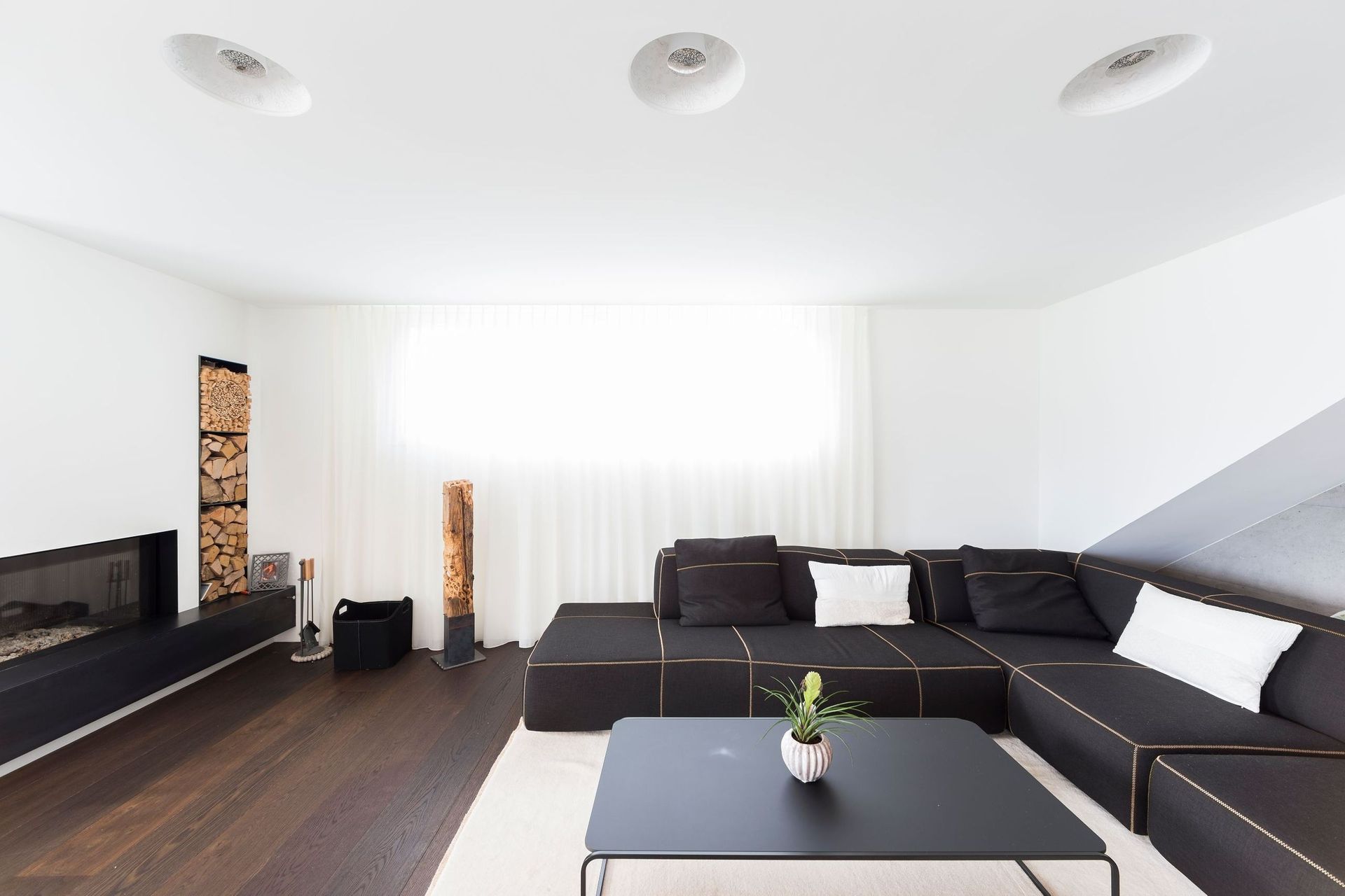 Ein Wohnzimmer mit einer schwarzen Couch und einem schwarzen Couchtisch