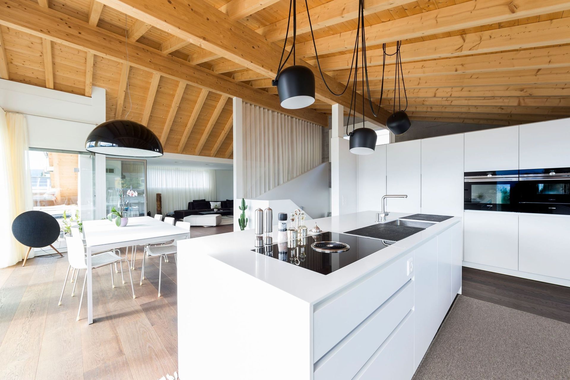 Eine Küche mit weißen Schränken und einer Holzdecke