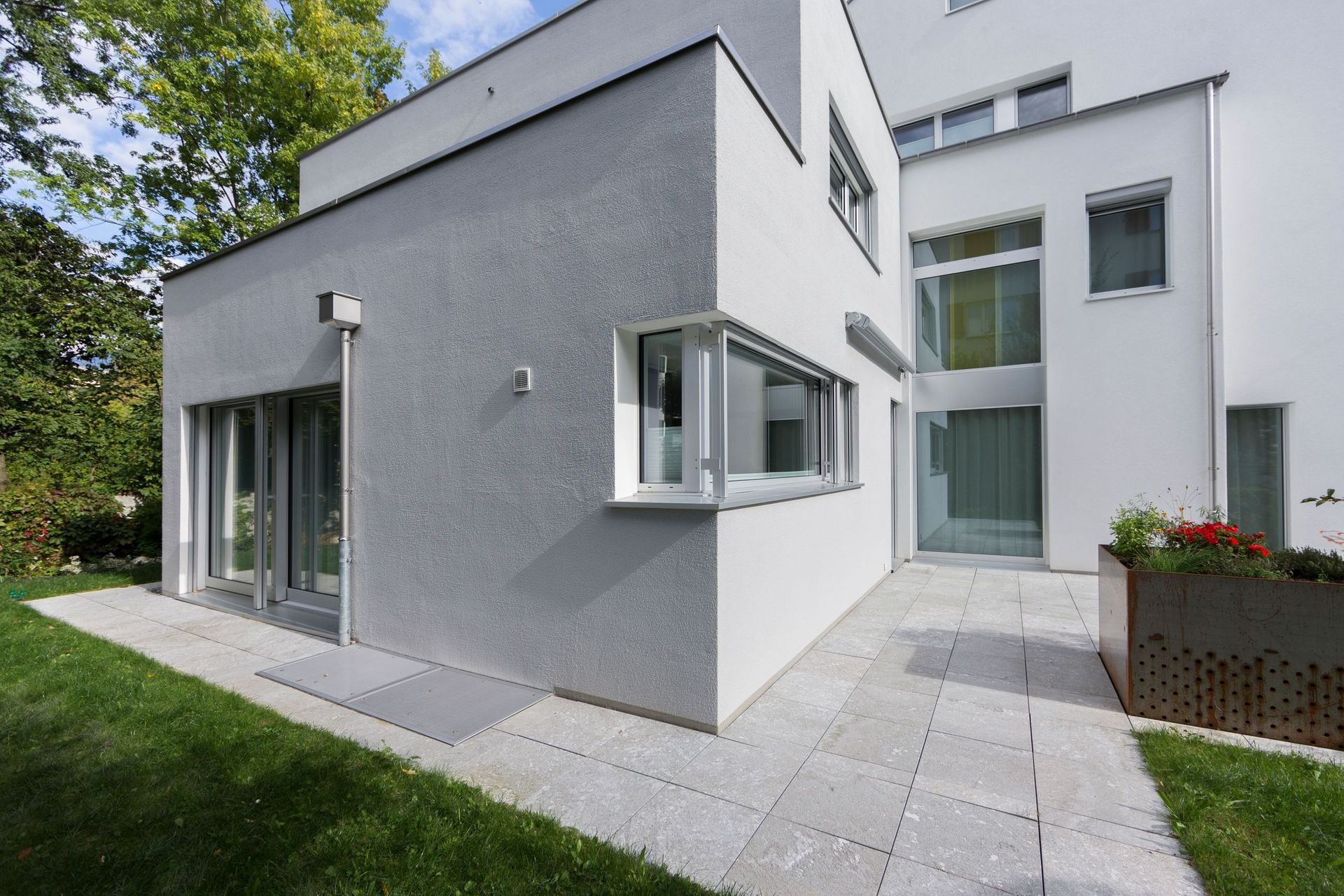 Ein großes weißes Haus mit einer Terrasse davor