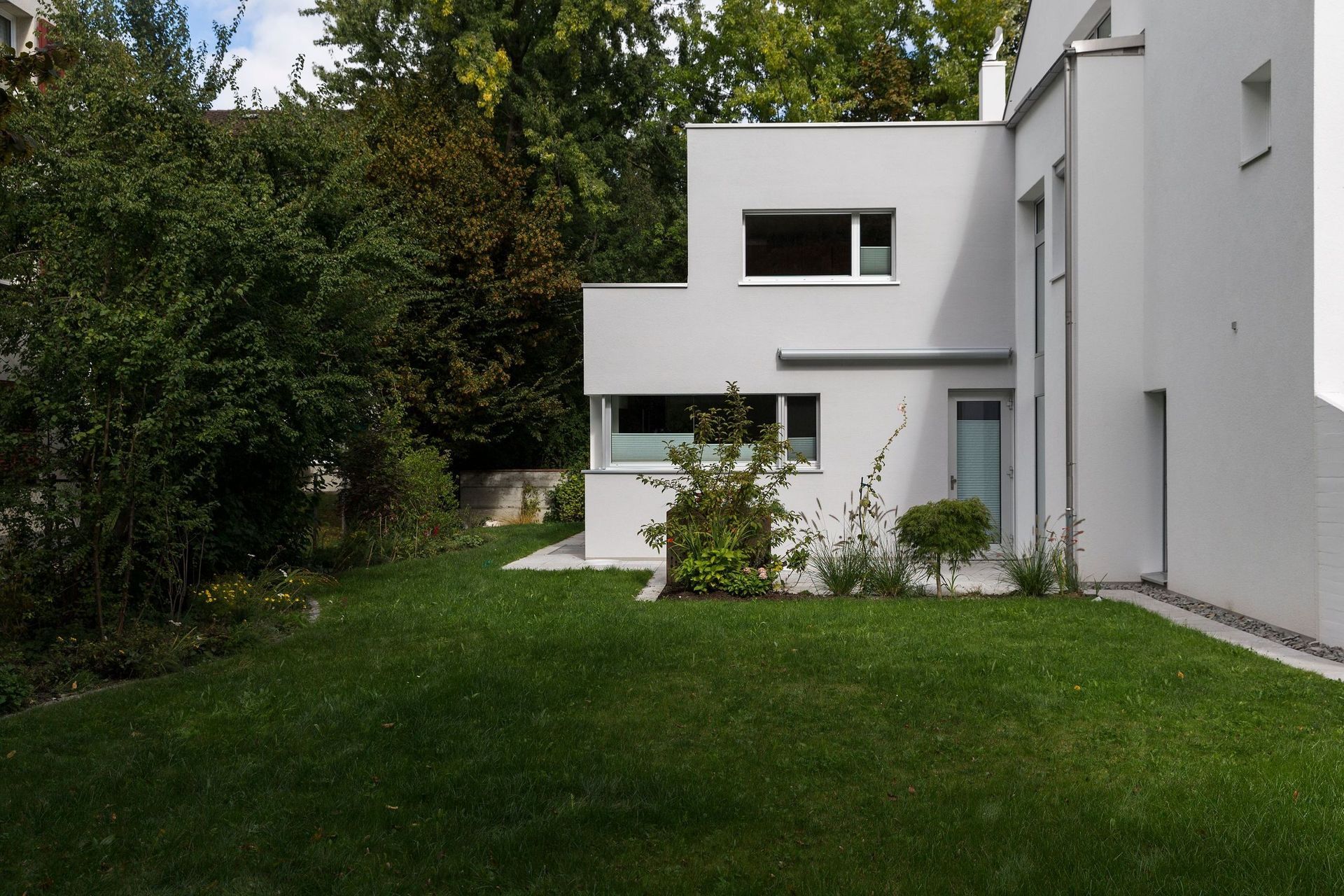 Ein weißes Haus mit einem üppigen grünen Rasen davor