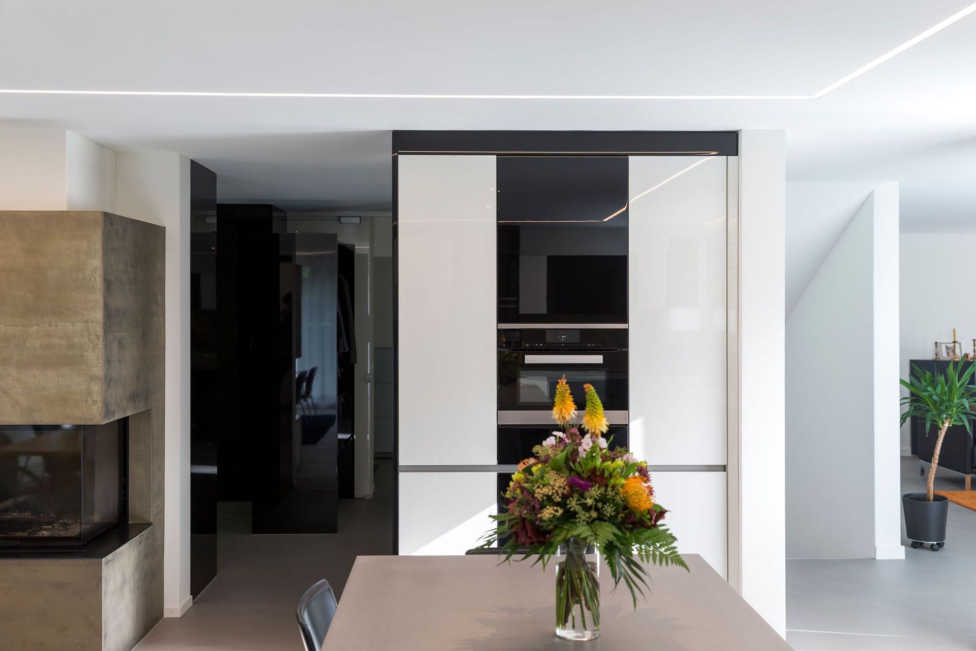 Auf dem Küchentisch steht eine Vase mit Blumen.