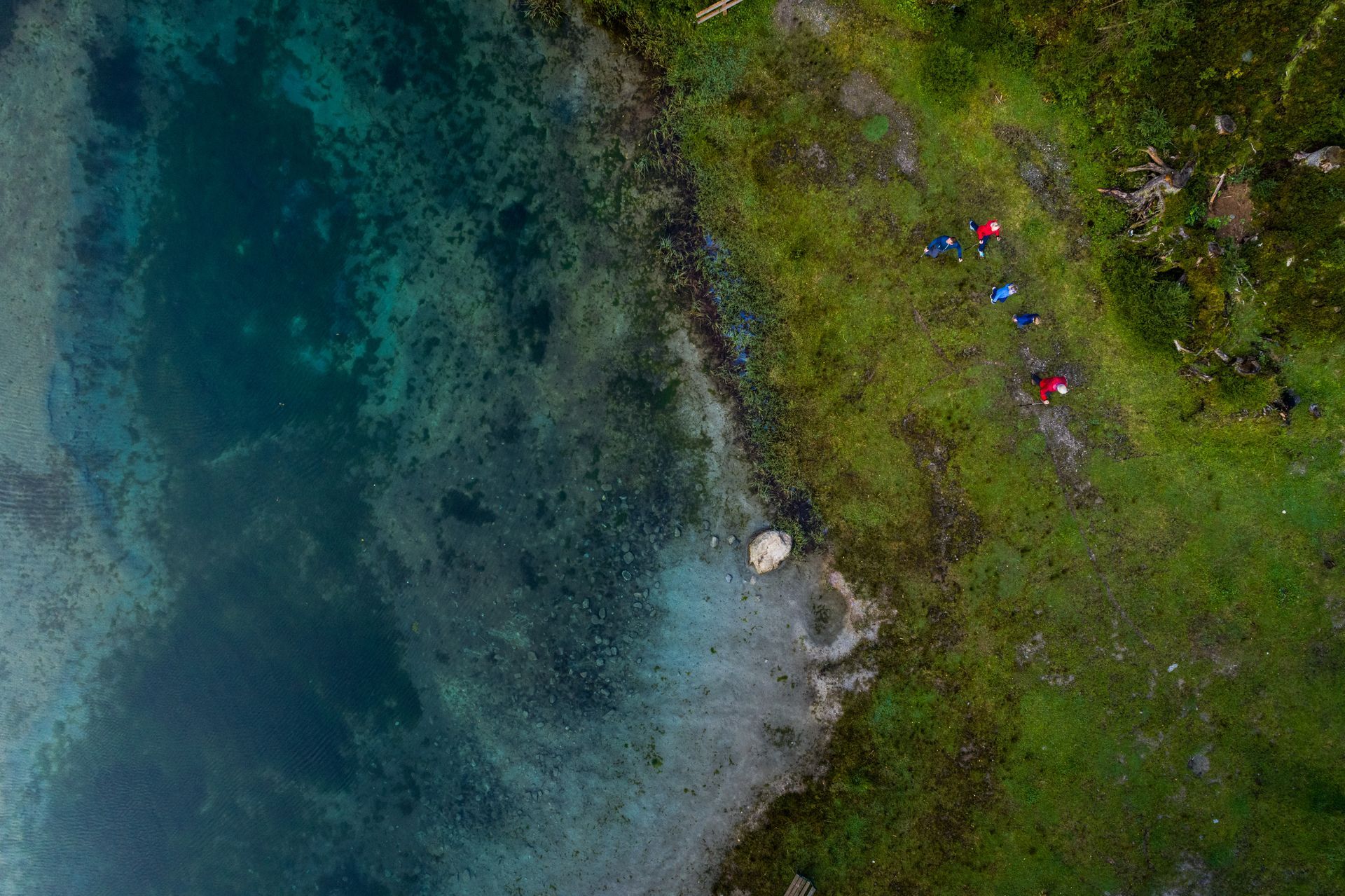 Eine Luftaufnahme einer Gruppe von Menschen, die am Ufer eines Sees campen.