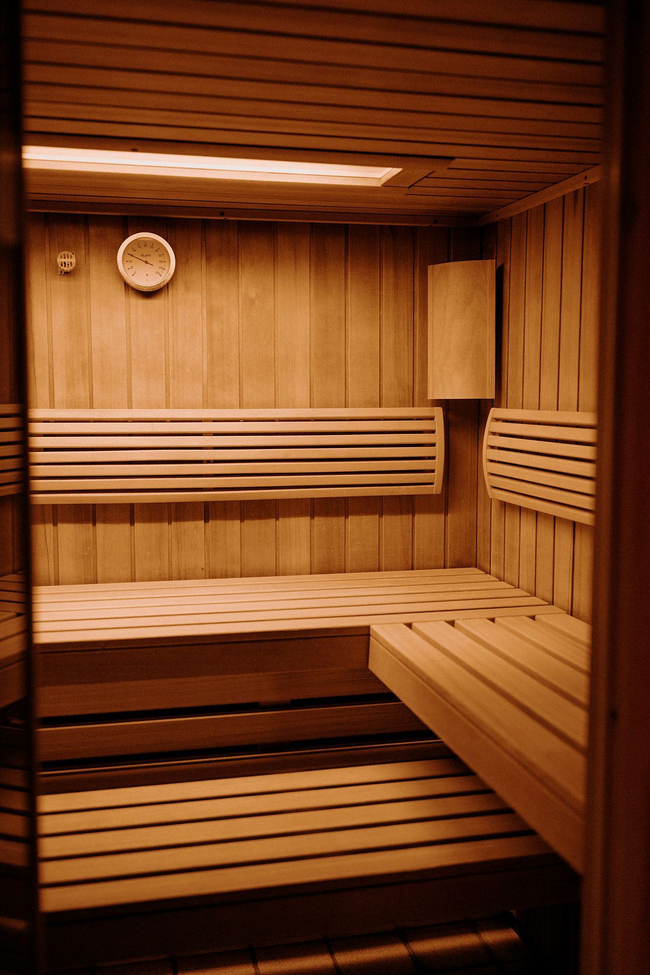 Eine Holzsauna mit einer Uhr an der Wand.