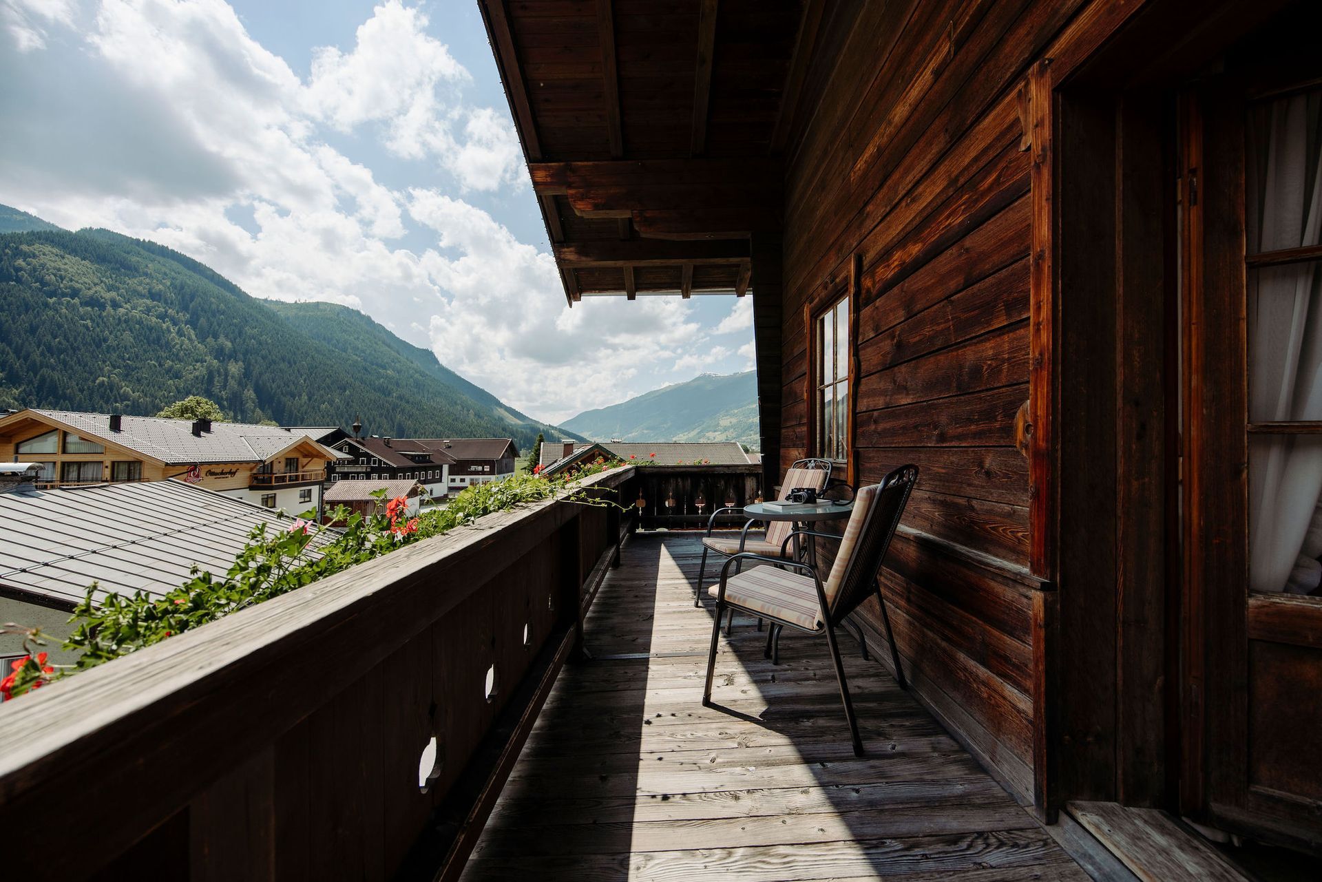 Eine Frau sitzt im Sessel und liest während zwei Kinder gemütlich auf einem Bett liegen in einem Hotel im Salzburger Land.