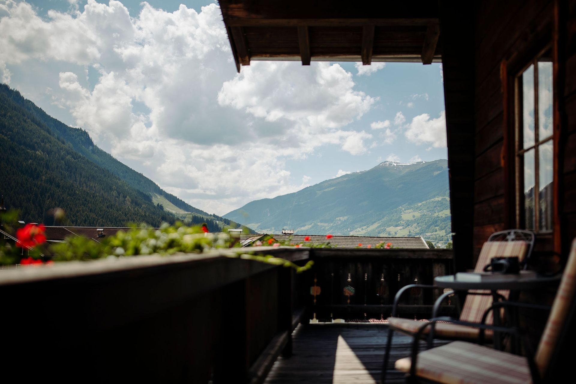 Ein Balkon mit Blick auf die Berge sowie einem Tisch und StĂźhlen.