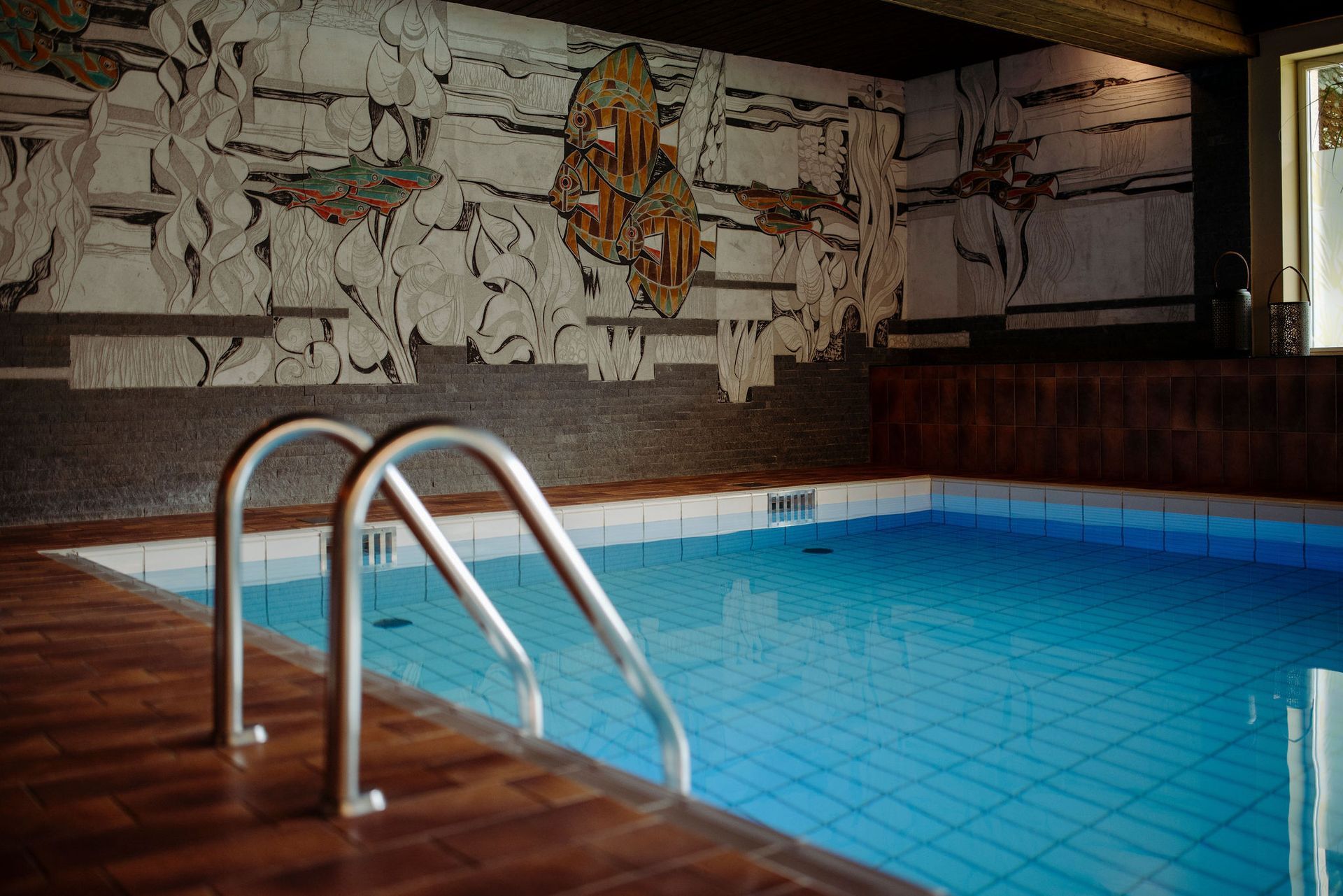 Ein Hallenbad mit einem Wandgemälde an der Wand dahinter.