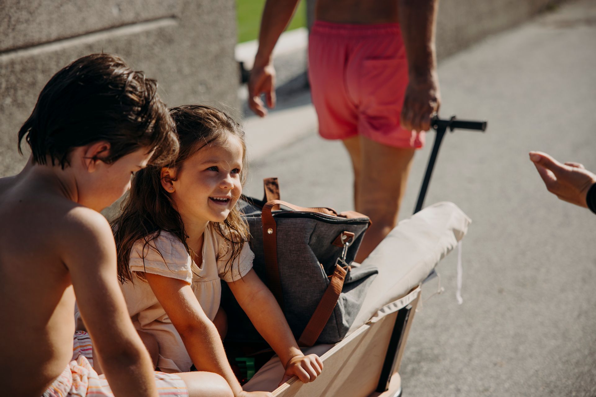 Eine Mutter lächelt ihre Töchter auf dem Berg beim Skifahren an. 