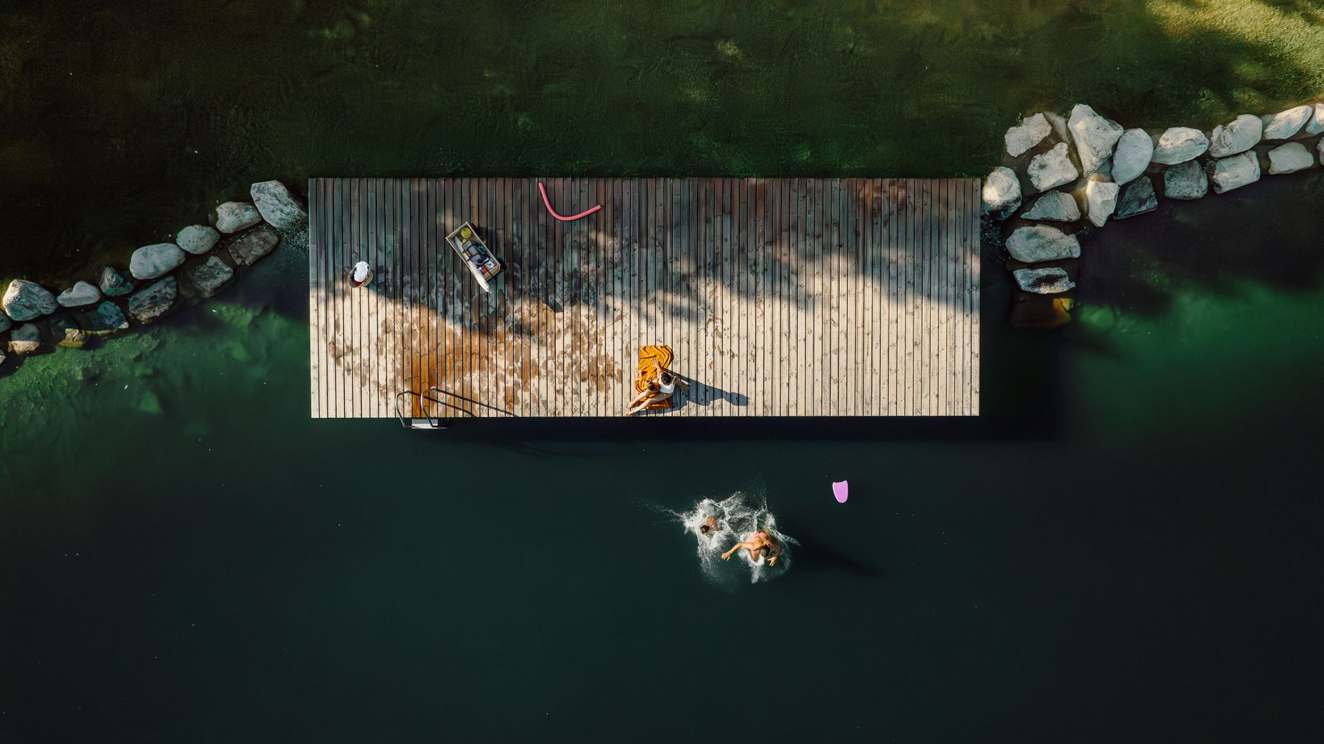 Eine Luftaufnahme eines Holzstegs in der Mitte eines Sees.