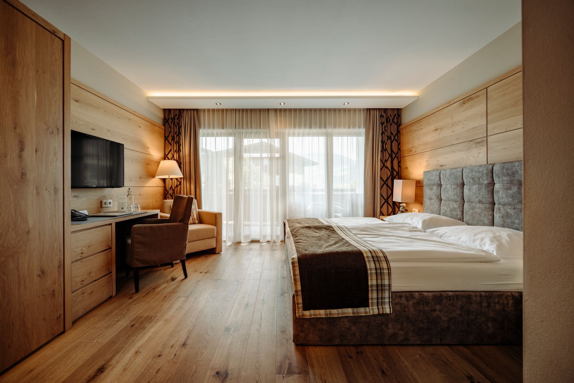 Ein Hotelzimmer mit zwei Betten, einem Schreibtisch, einem Stuhl und einem Fernseher.