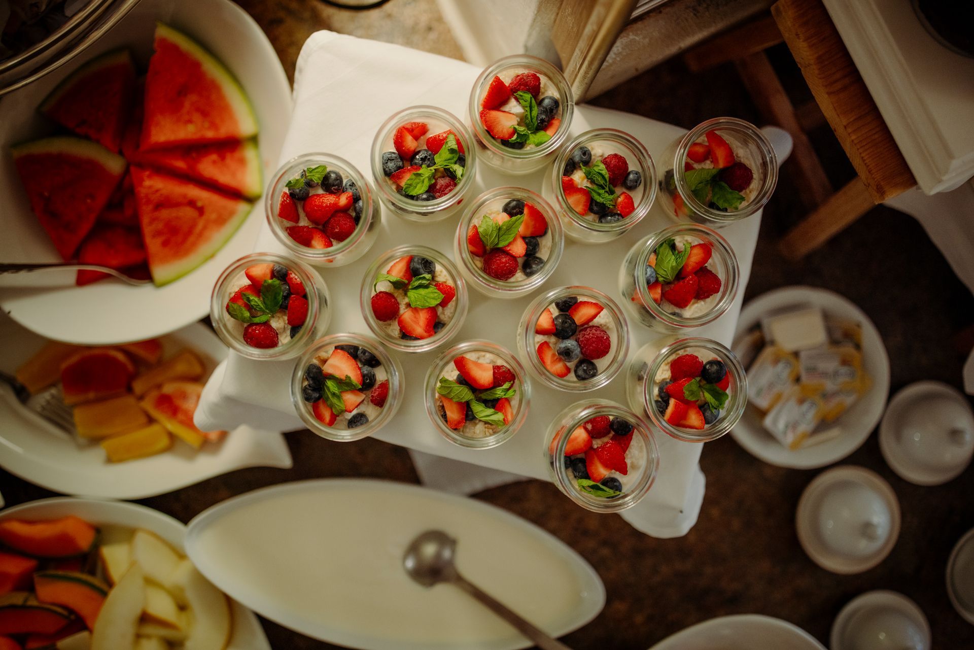 Ein Tisch mit Schalen voller Obst und Desserts.