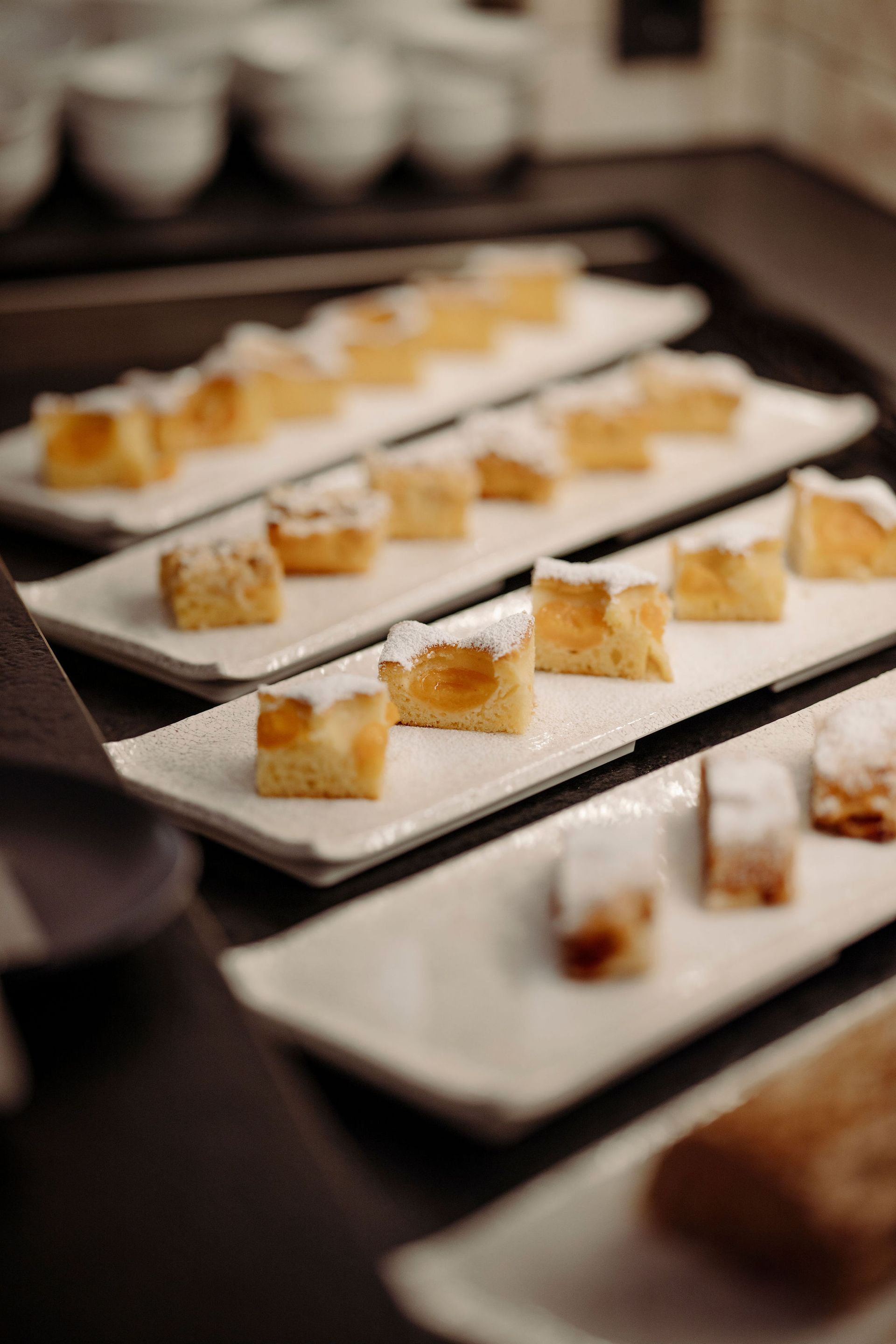 Ein Tablett mit Desserts auf weißen Tellern auf einem Tisch.