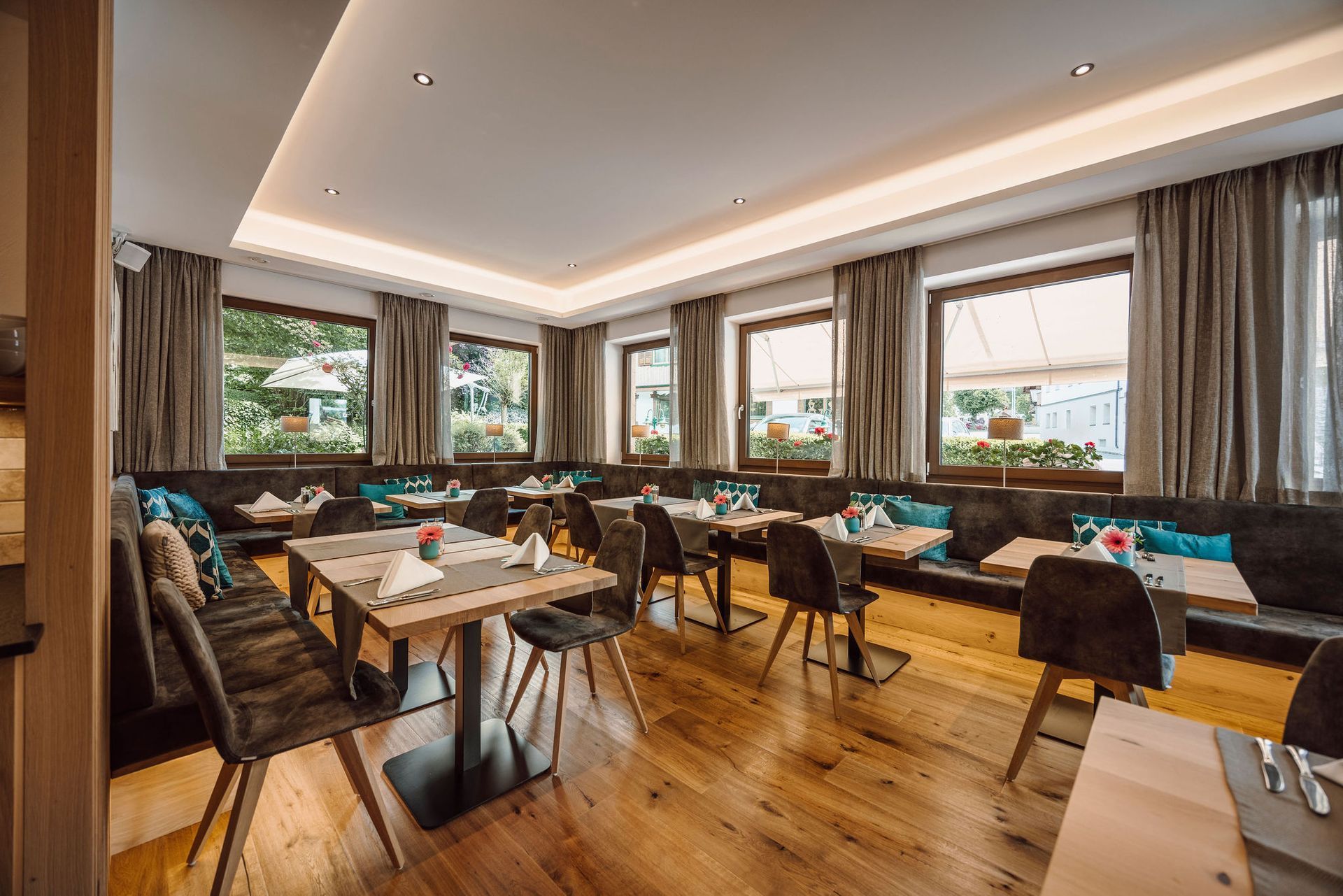 Ein Restaurant mit Tischen und Stühlen und vielen Fenstern.