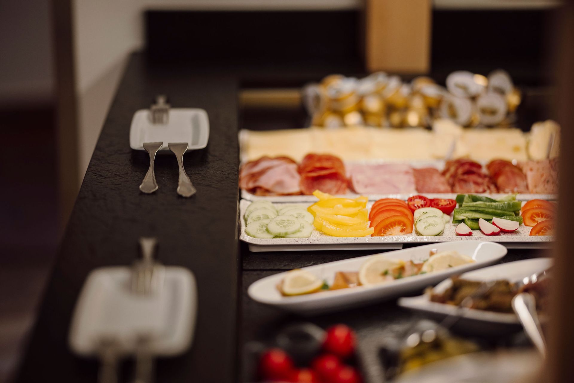 Ein Buffet-Tisch mit Tellern voller Essen und Besteck darauf.