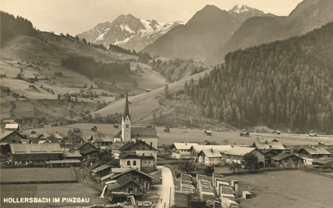 Ein SchwarzweiĂfoto eines Dorfes mit Bergen im Hintergrund