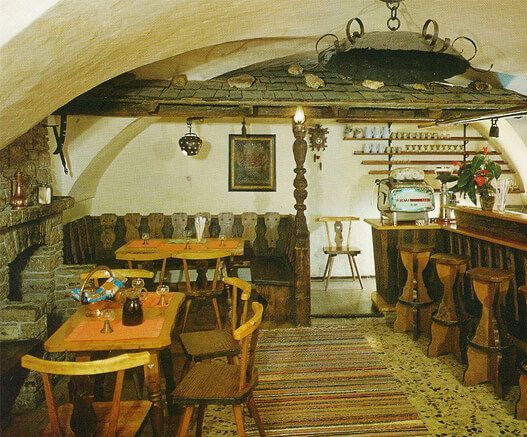 Ein Raum mit Tischen und Stßhlen und einem Gemälde an der Wand