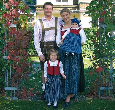 Eine Familie posiert fĂźr ein Foto vor einem Haus