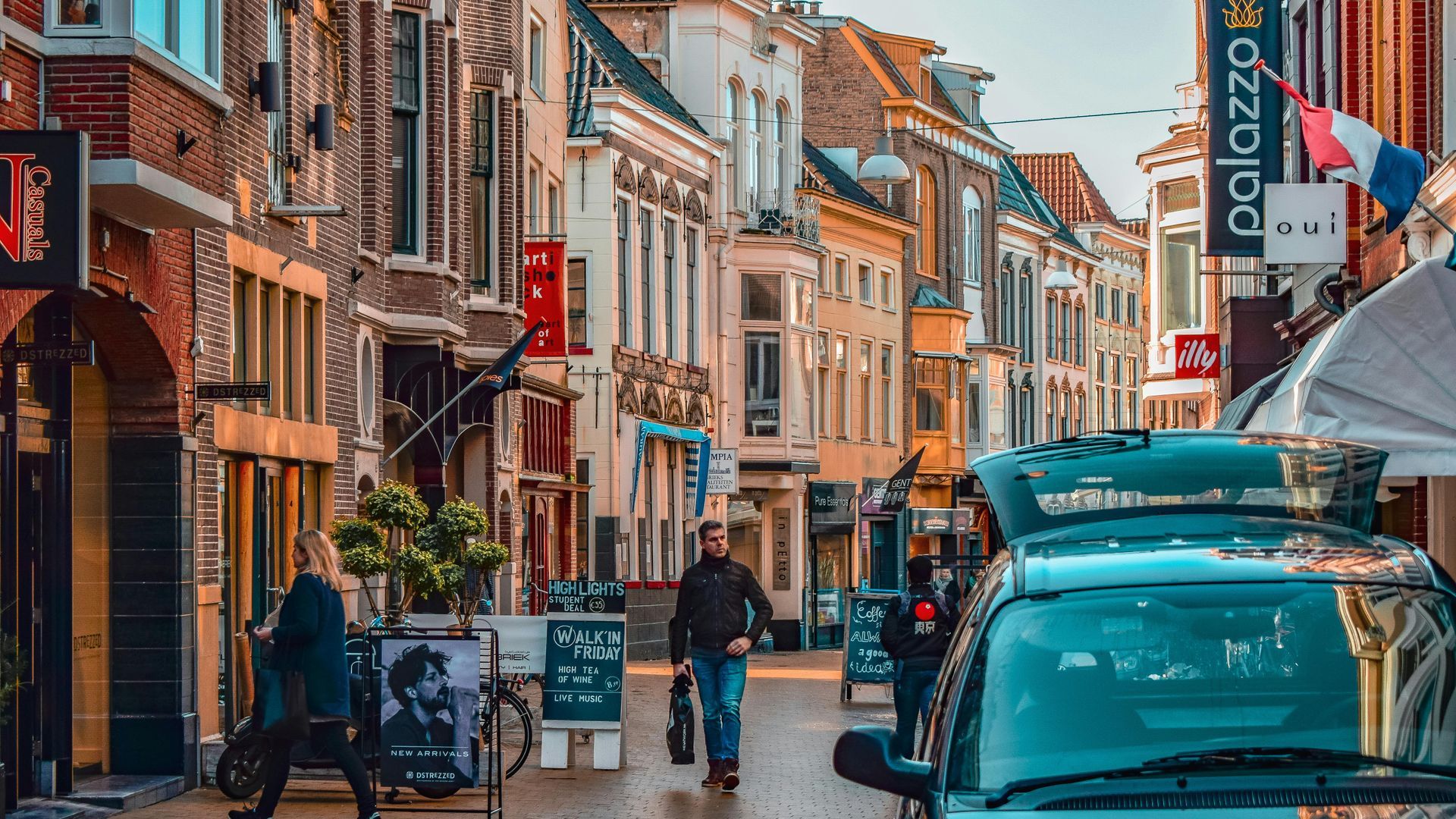 Een man loopt door een smalle straat in een stad.