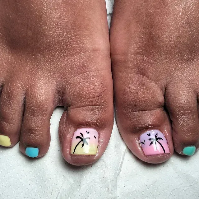 Dedos de los pies pedicurados con diseño de palmeras; tonos de amarillo, rosa, azul y verde.