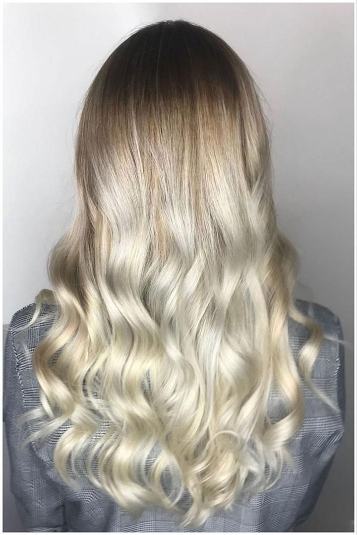 Der Hinterkopf einer Frau mit langen blonden Haaren.