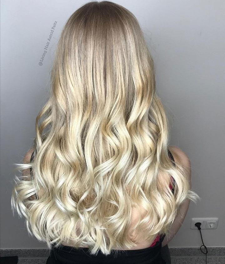 Zu sehen ist der Rücken einer Frau mit langen blonden Haaren.