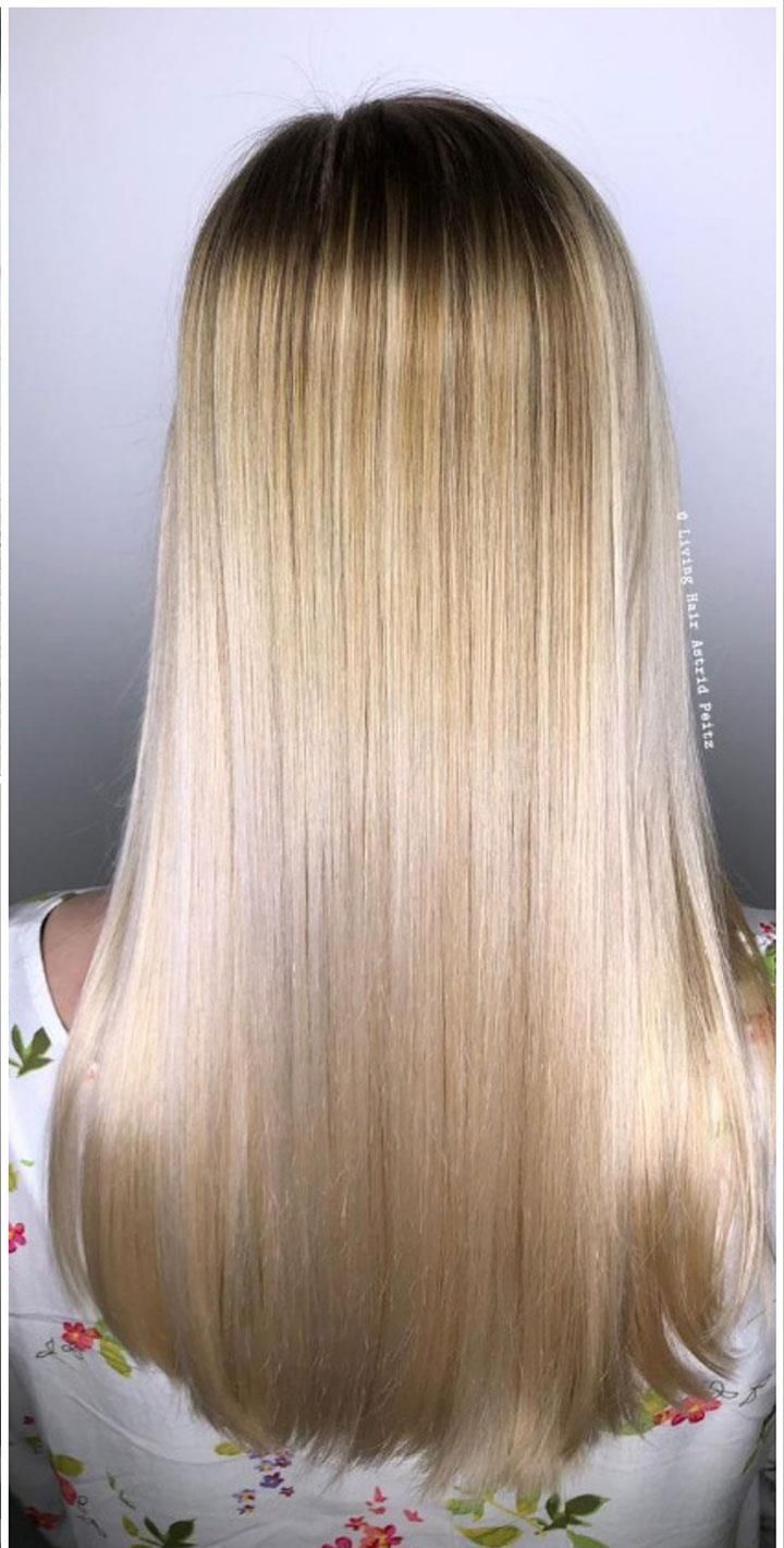 Der Hinterkopf einer Frau mit langen blonden Haaren.