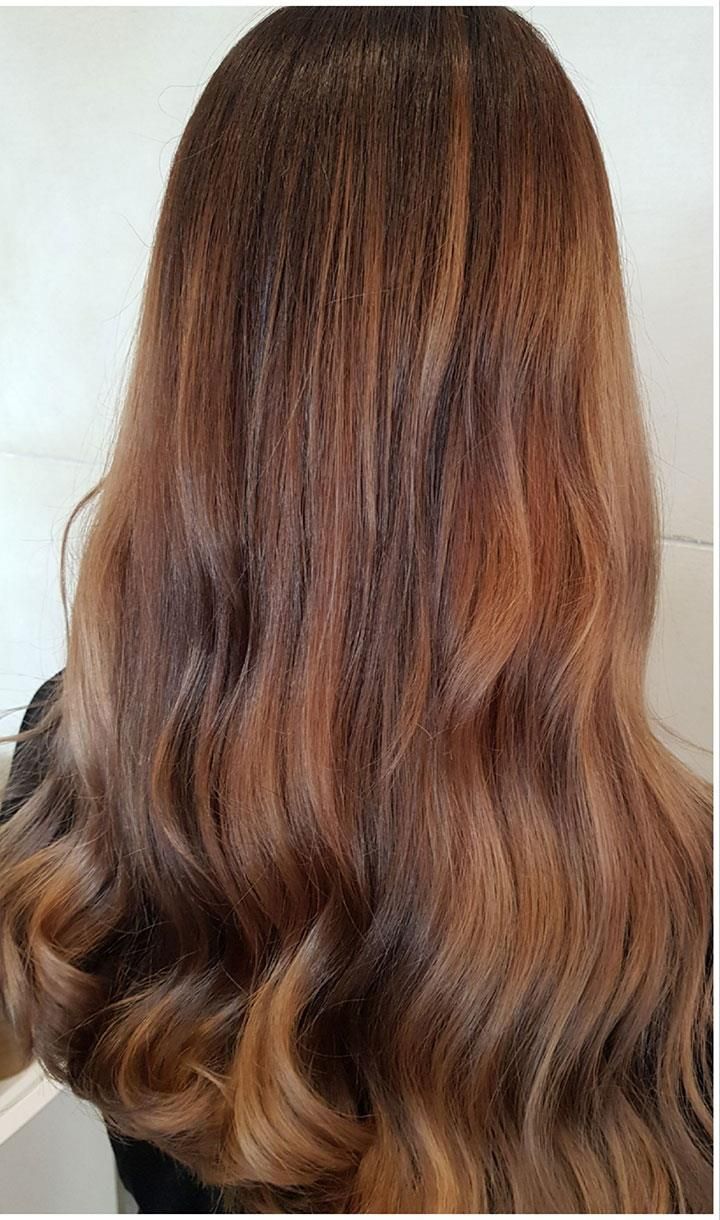 Der Hinterkopf einer Frau mit langen braunen Haaren.