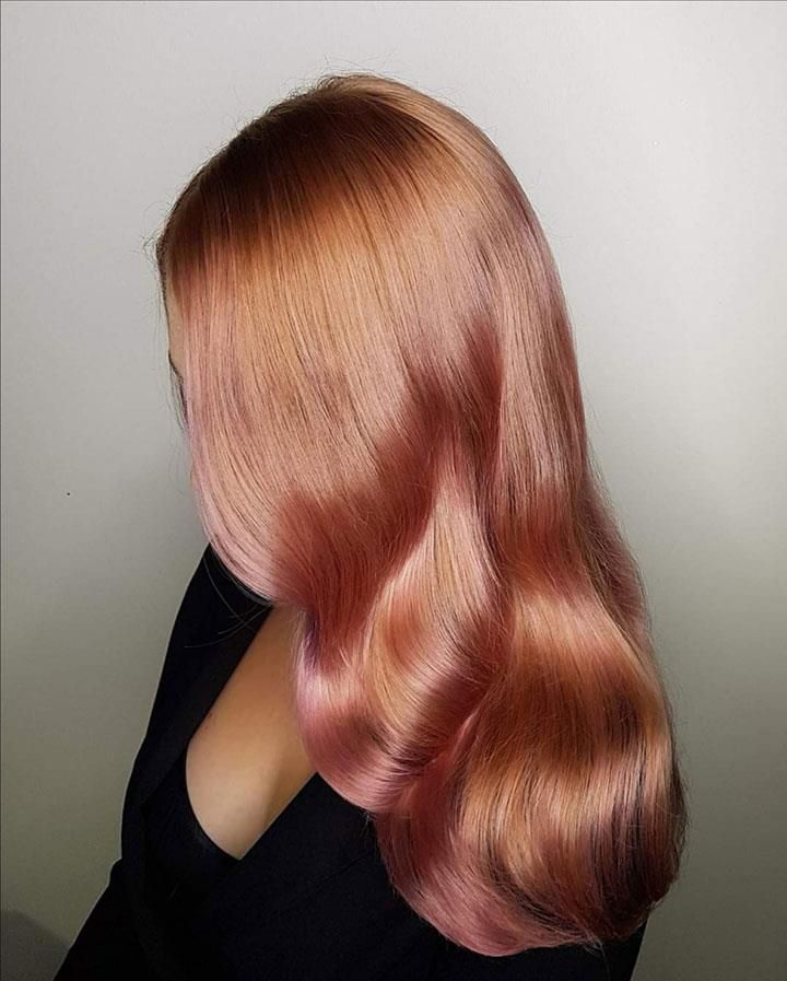 Eine Frau mit langen rosa Haaren trägt ein schwarzes Hemd.