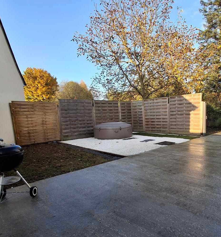 Jardin avec un bain à remous circulaire, une clôture en bois pour plus d’intimité