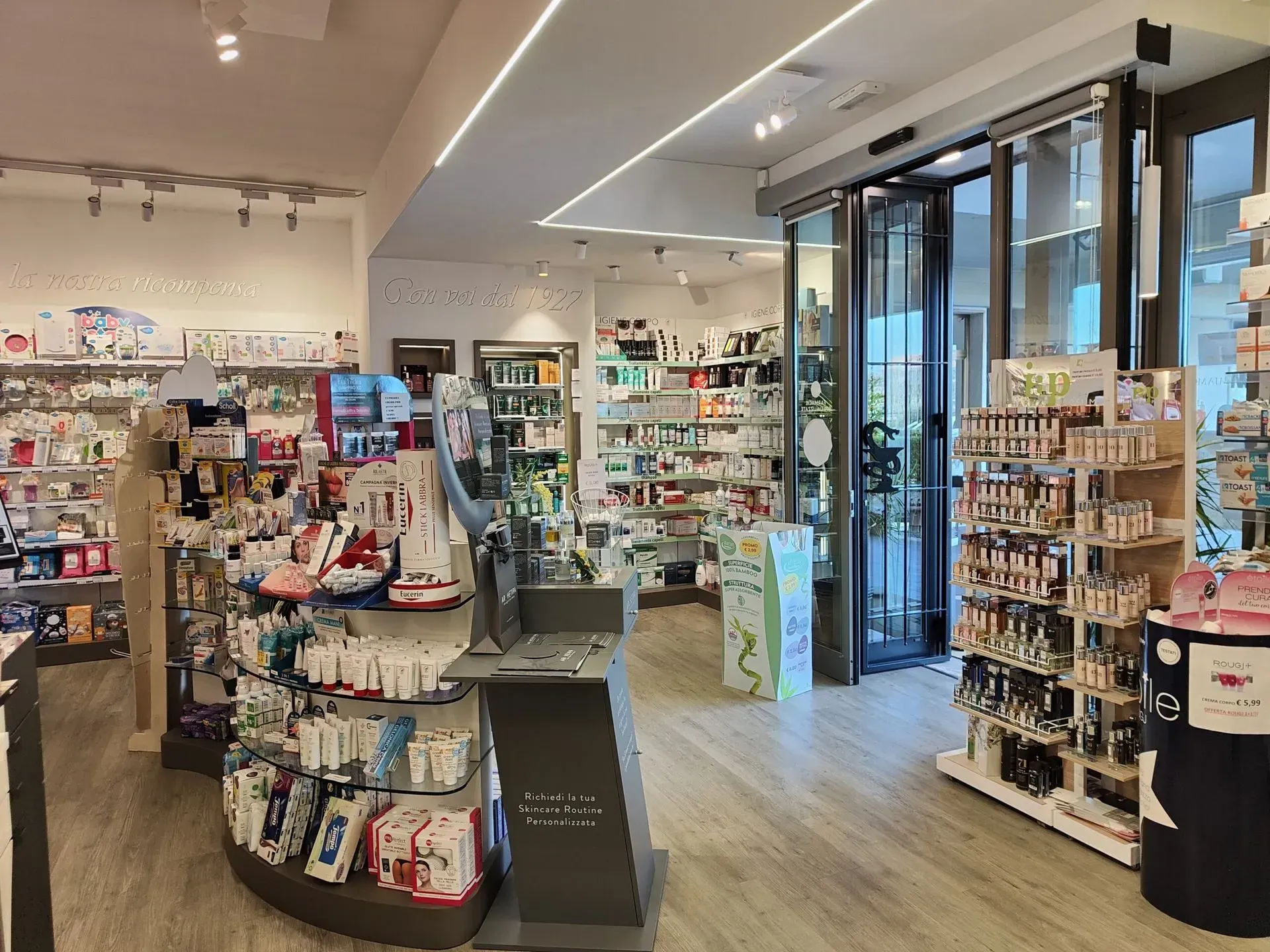 Luminoso interno della farmacia con scaffali di prodotti per la salute e la bellezza e porte d'ingresso in vetro.