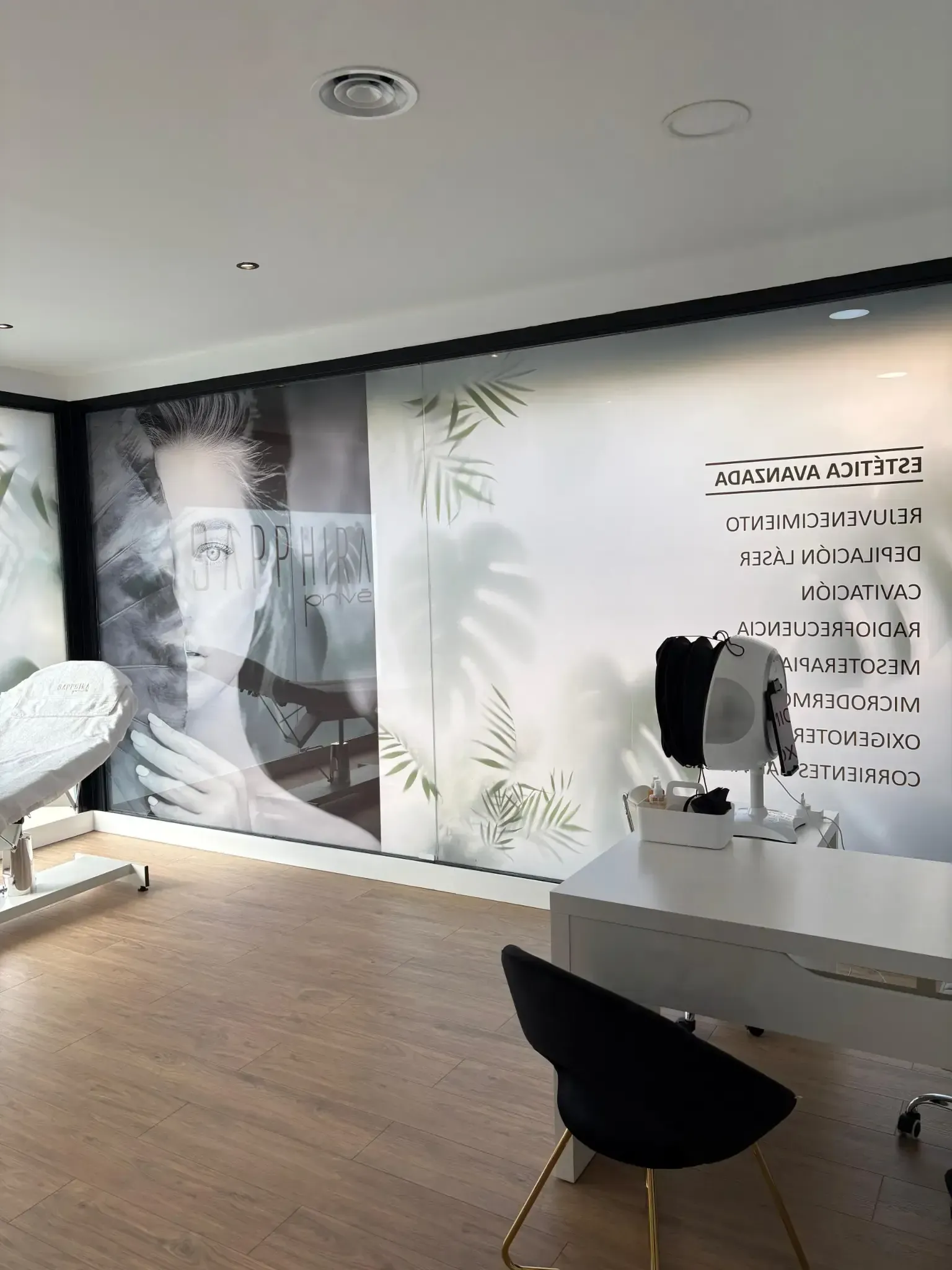 Un interior de oficina moderno con un gran mural de una cara y un escritorio con una silla negra.