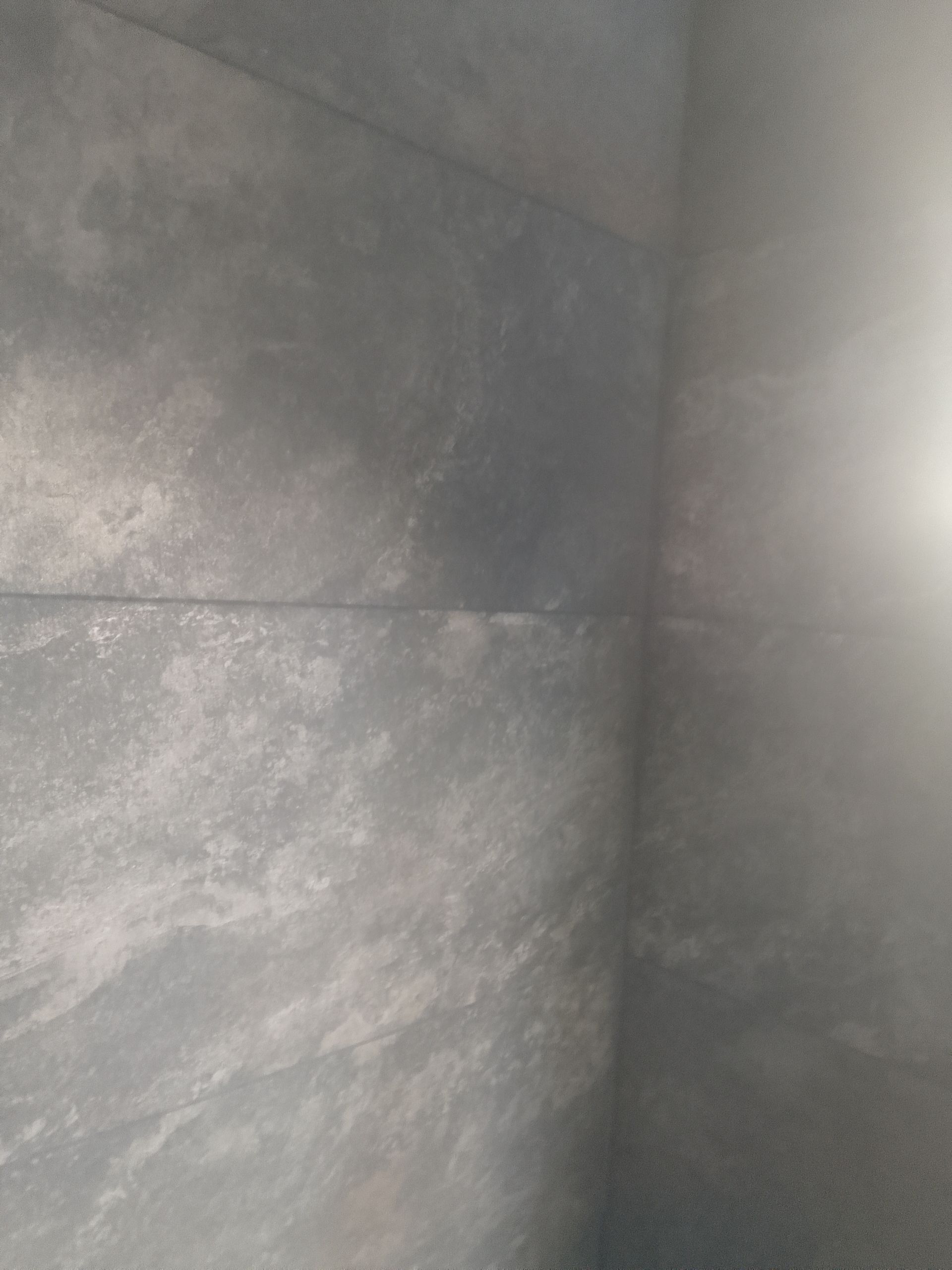 Gros plan sur un mur gris texturé.