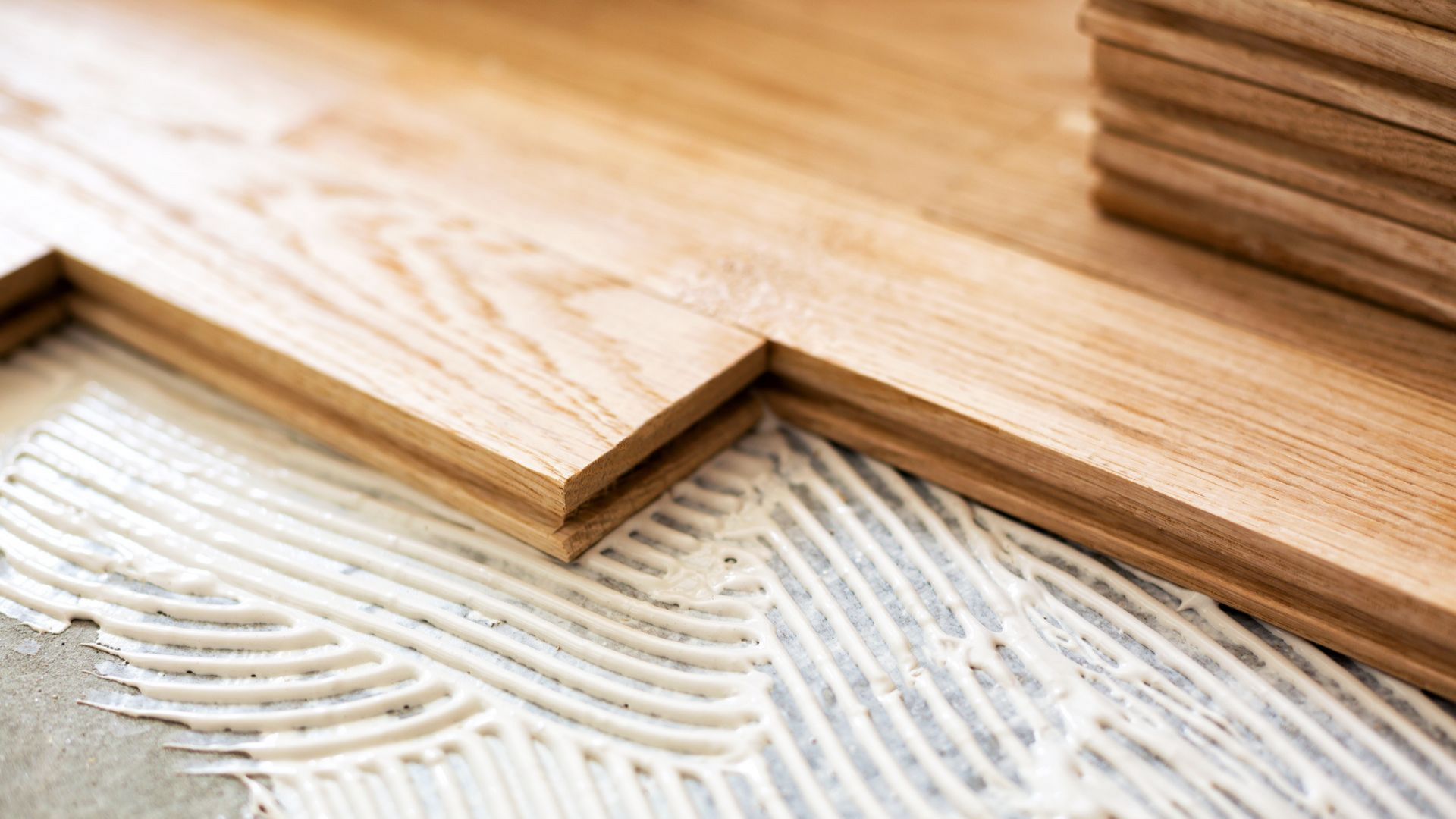 Pose de lames de parquet sur de la colle.