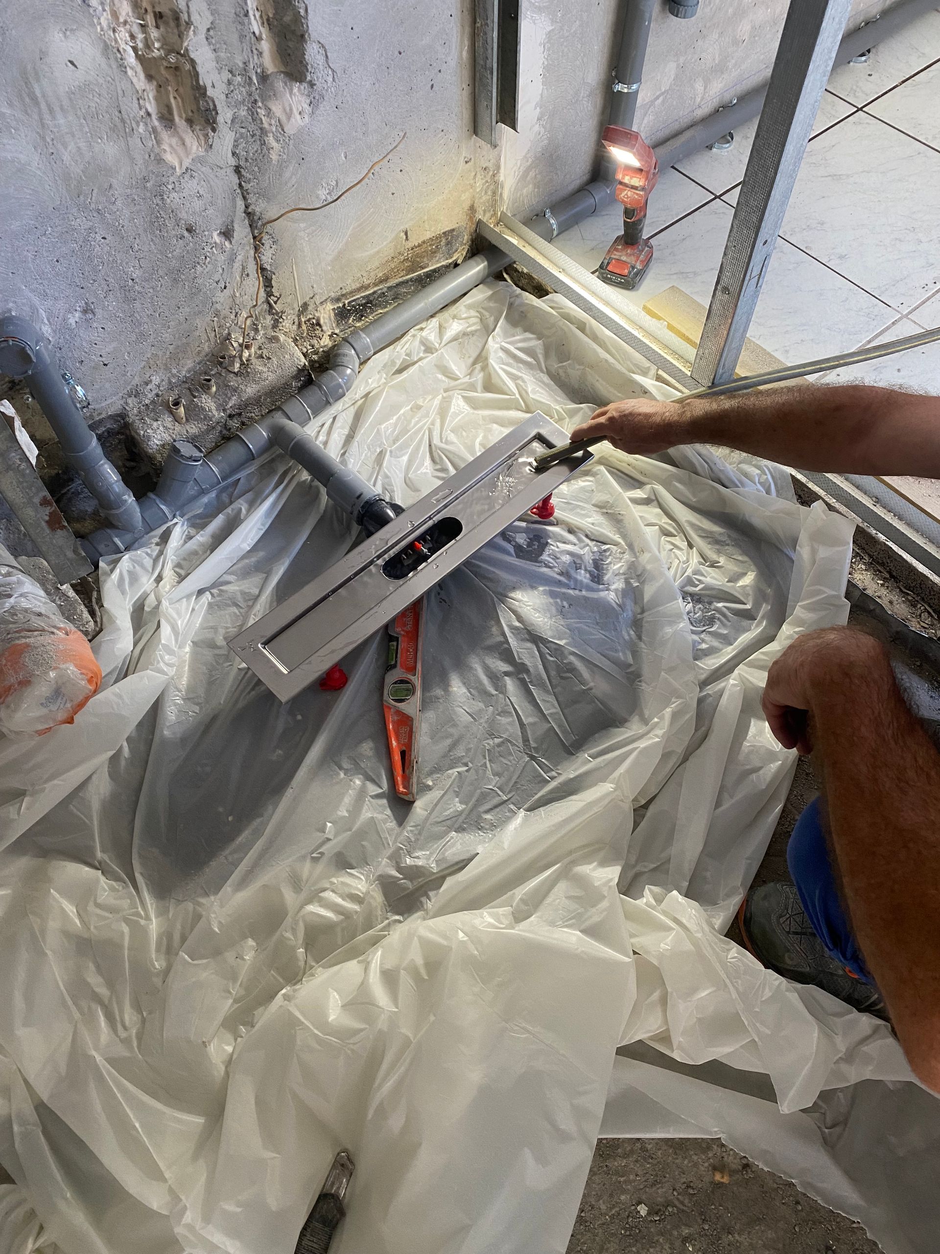 Un ouvrier utilise un niveau à bulle sur un chantier de rénovation intérieure.