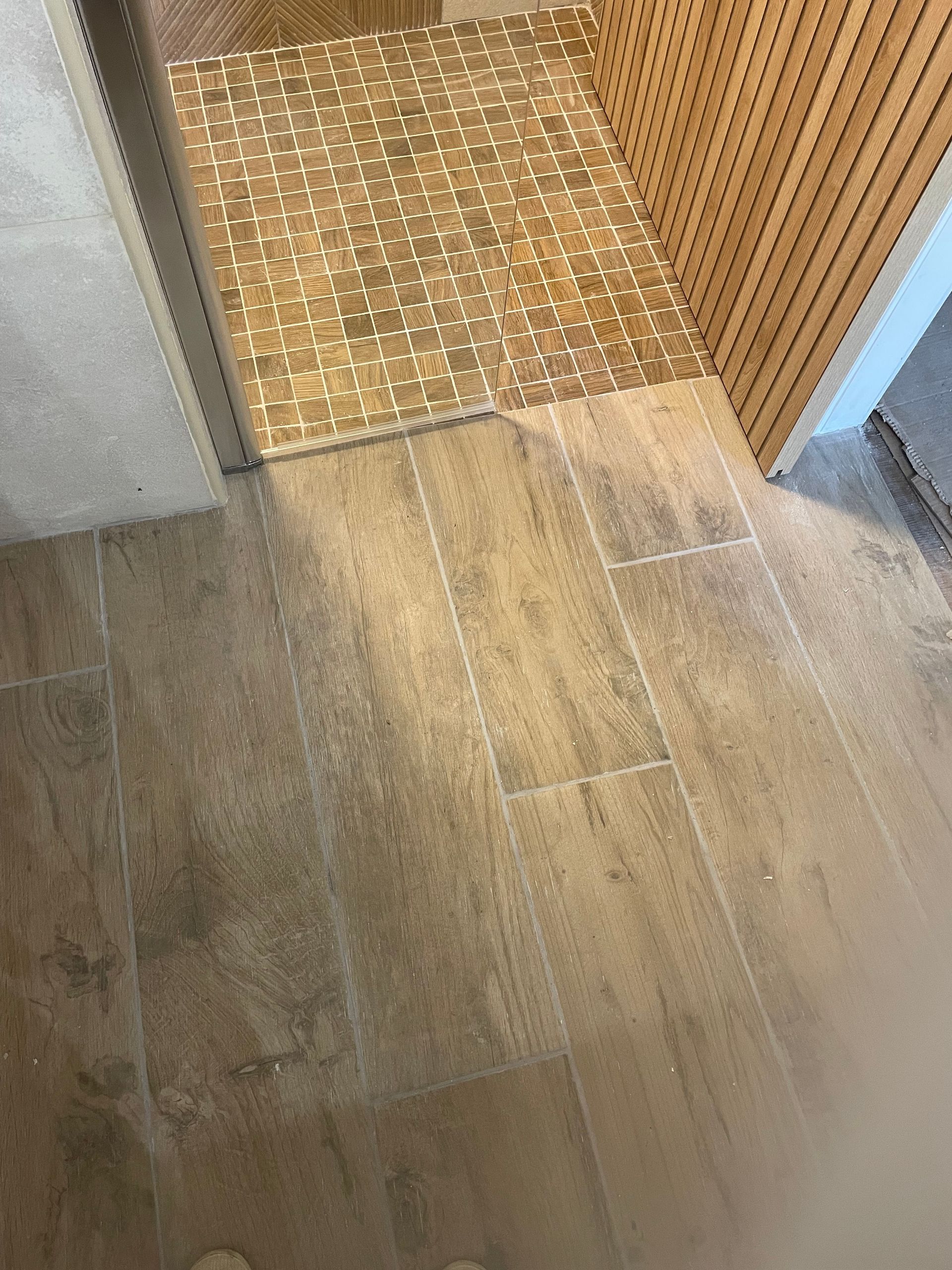 Vue de dessus : le plancher et le seuil d'une douche à l'italienne se rencontrent.