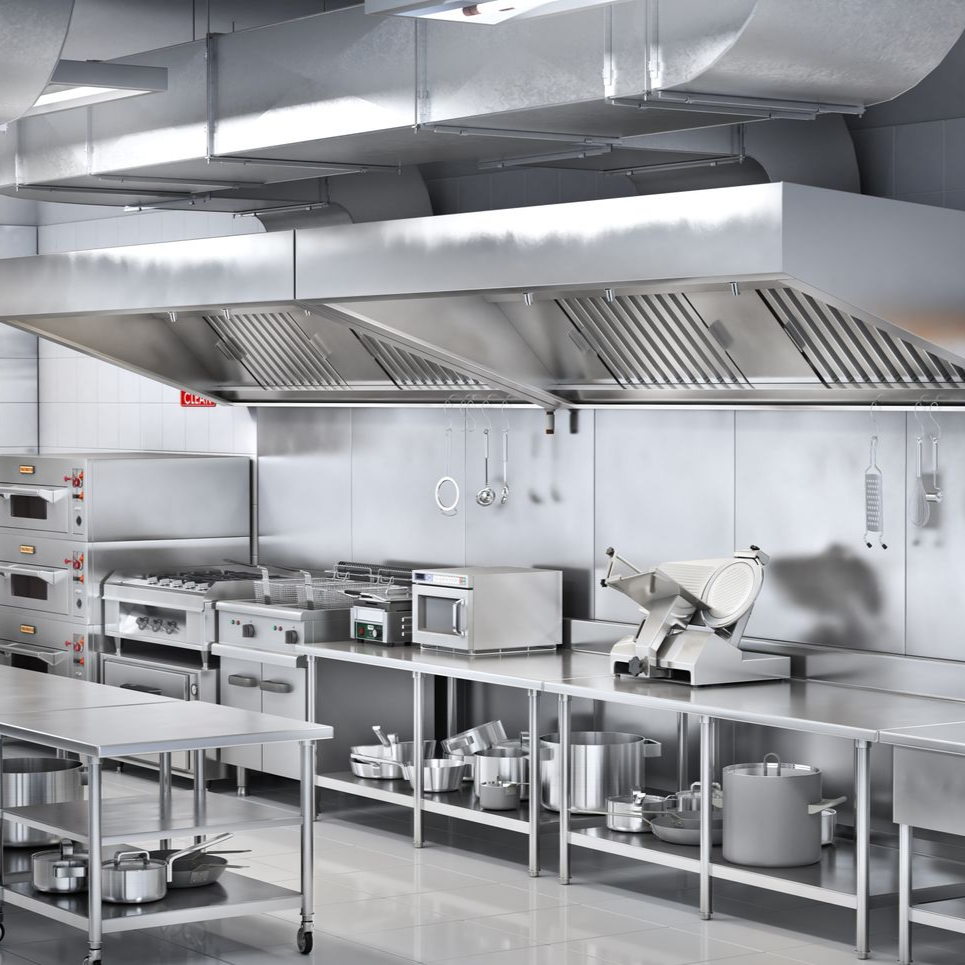 Cuisine commerciale équipée d'appareils en acier inoxydable, d'une hotte aspirante et de plans de travail.