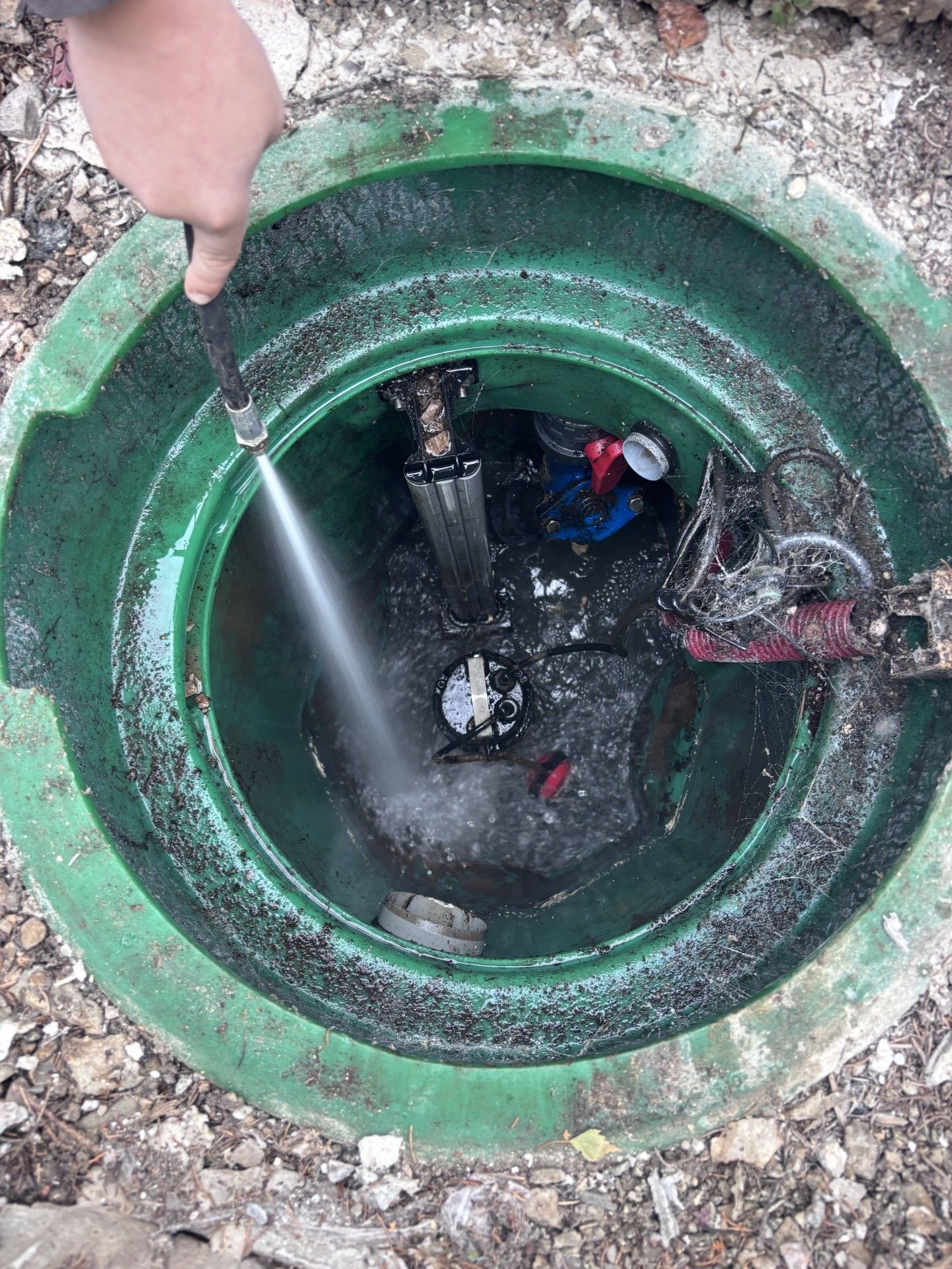 Pompe à eau électrique raccordée à des tuyaux blancs.