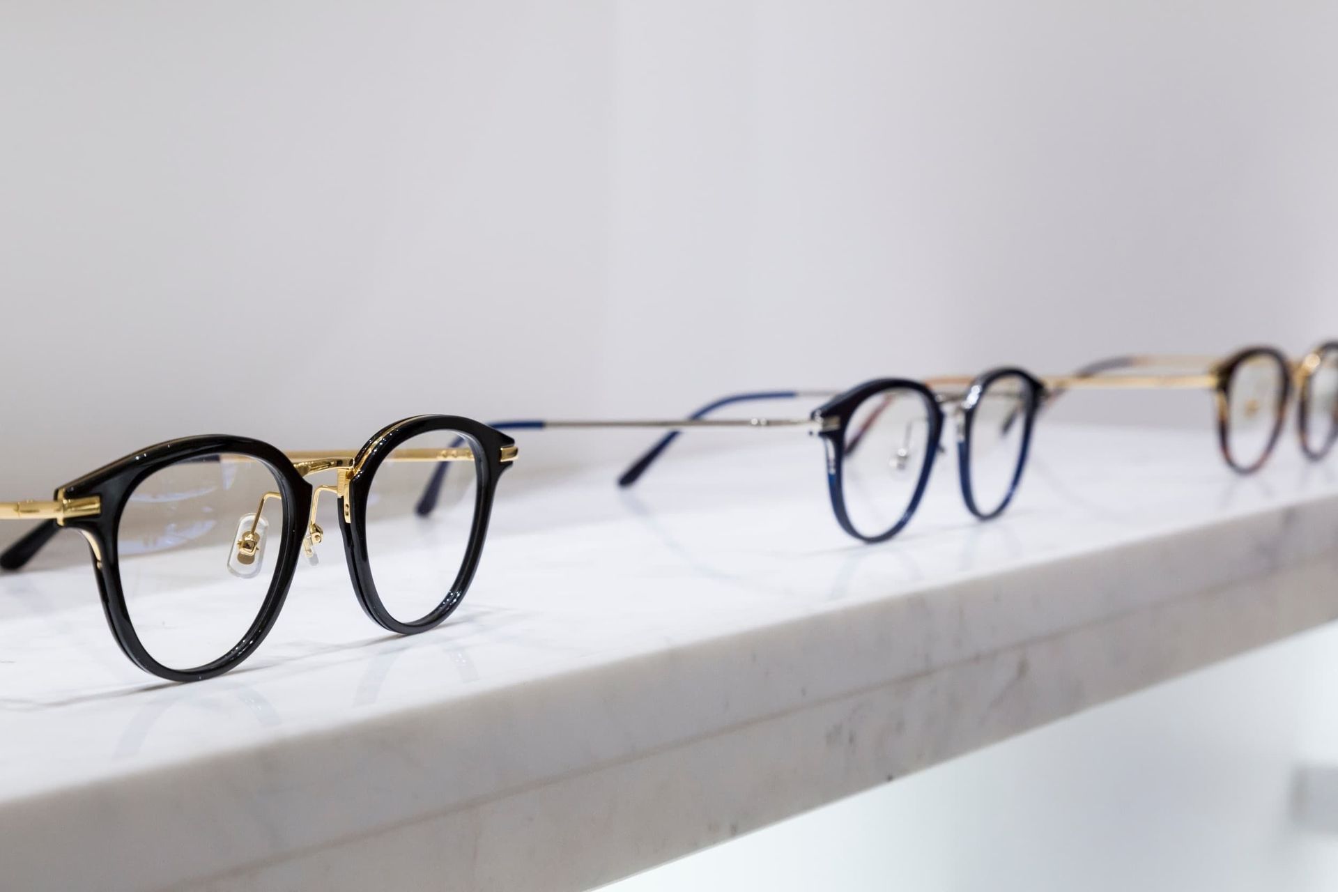 Una fila de vasos colocados encima de un estante blanco.