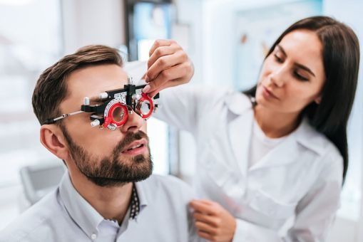 Un hombre se está haciendo un examen de la vista por parte de un oftalmólogo.
