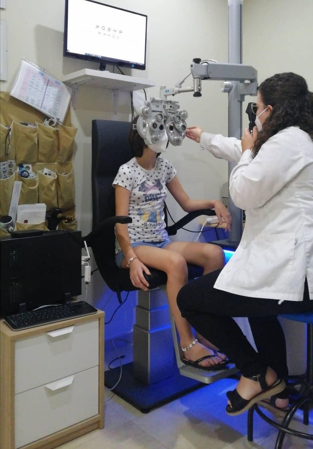 Una niña se está haciendo examinar los ojos por un oftalmólogo.