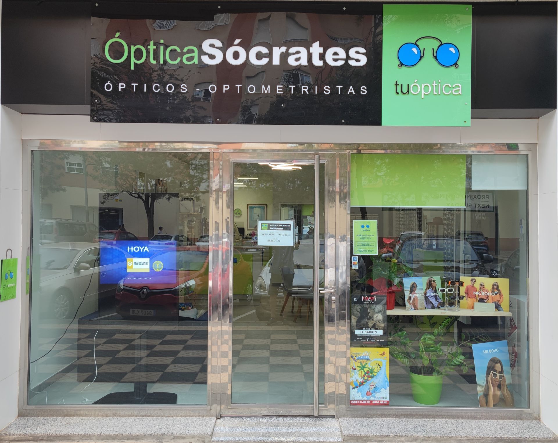 Un escaparate con un cartel que dice 'Optica Sócrates'.