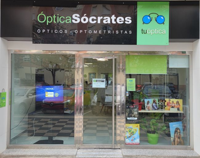 Un escaparate con un cartel que dice 'Optica Sócrates'.