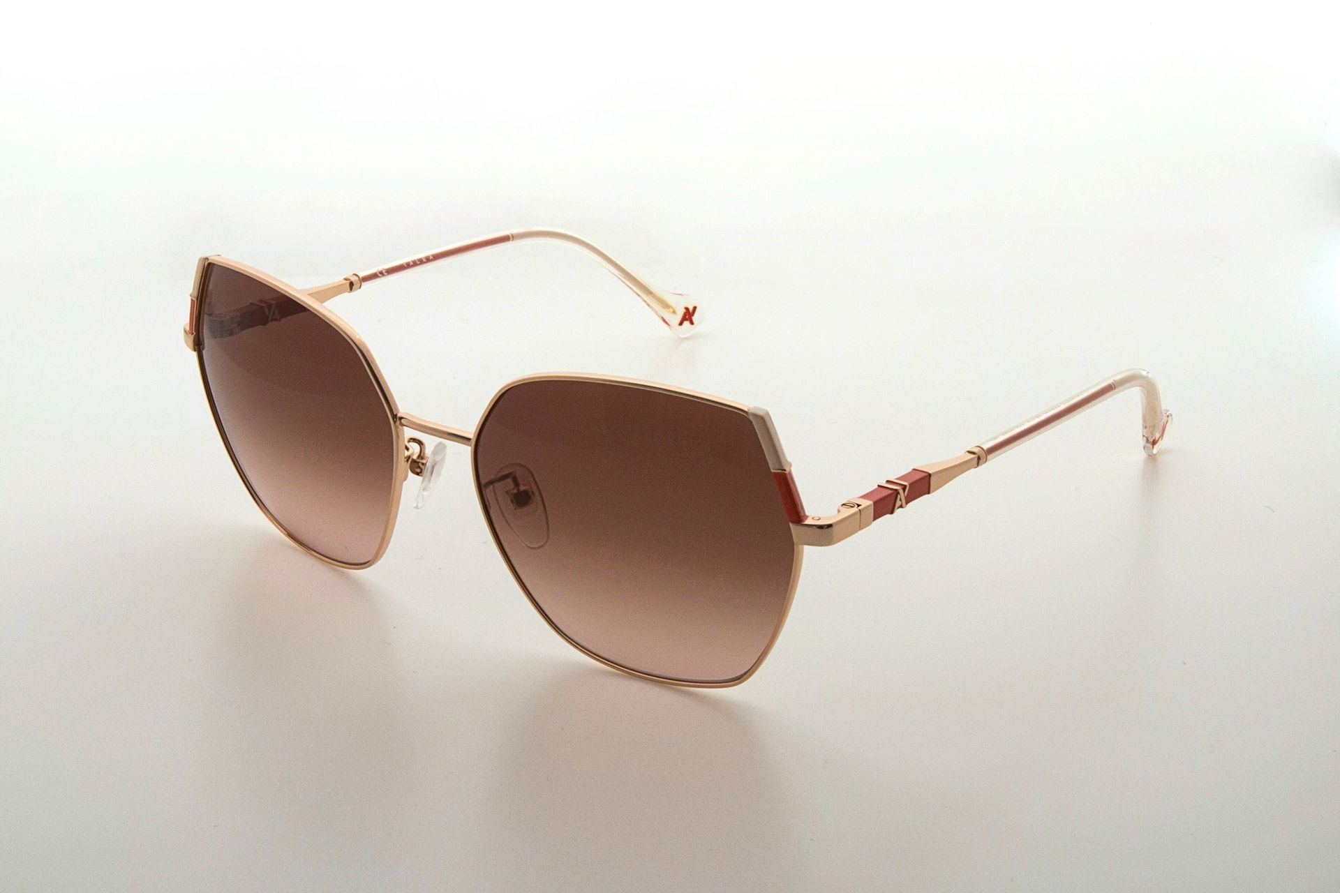 Un par de gafas de sol están sobre una superficie blanca.