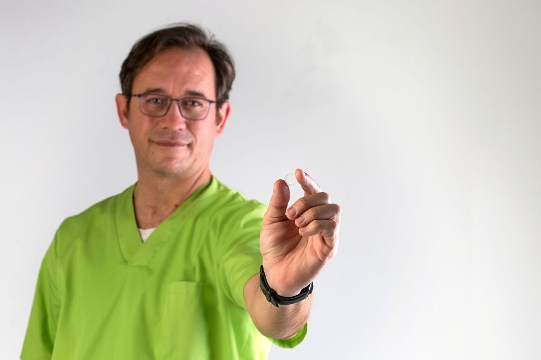 Un hombre con una blusa verde señala algo con su dedo.